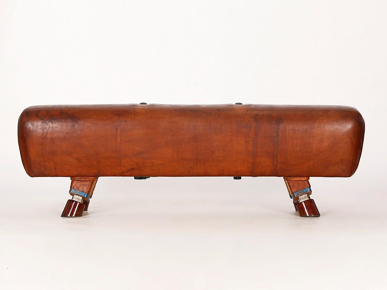 Pommel horse from former Czechoslovakia. The legs were cut to a height of 53cm. The handles can be removed for comfortable seating. The wooden handles were restored. The thick leather has been cleaned and the patina was retained. Very good vintage