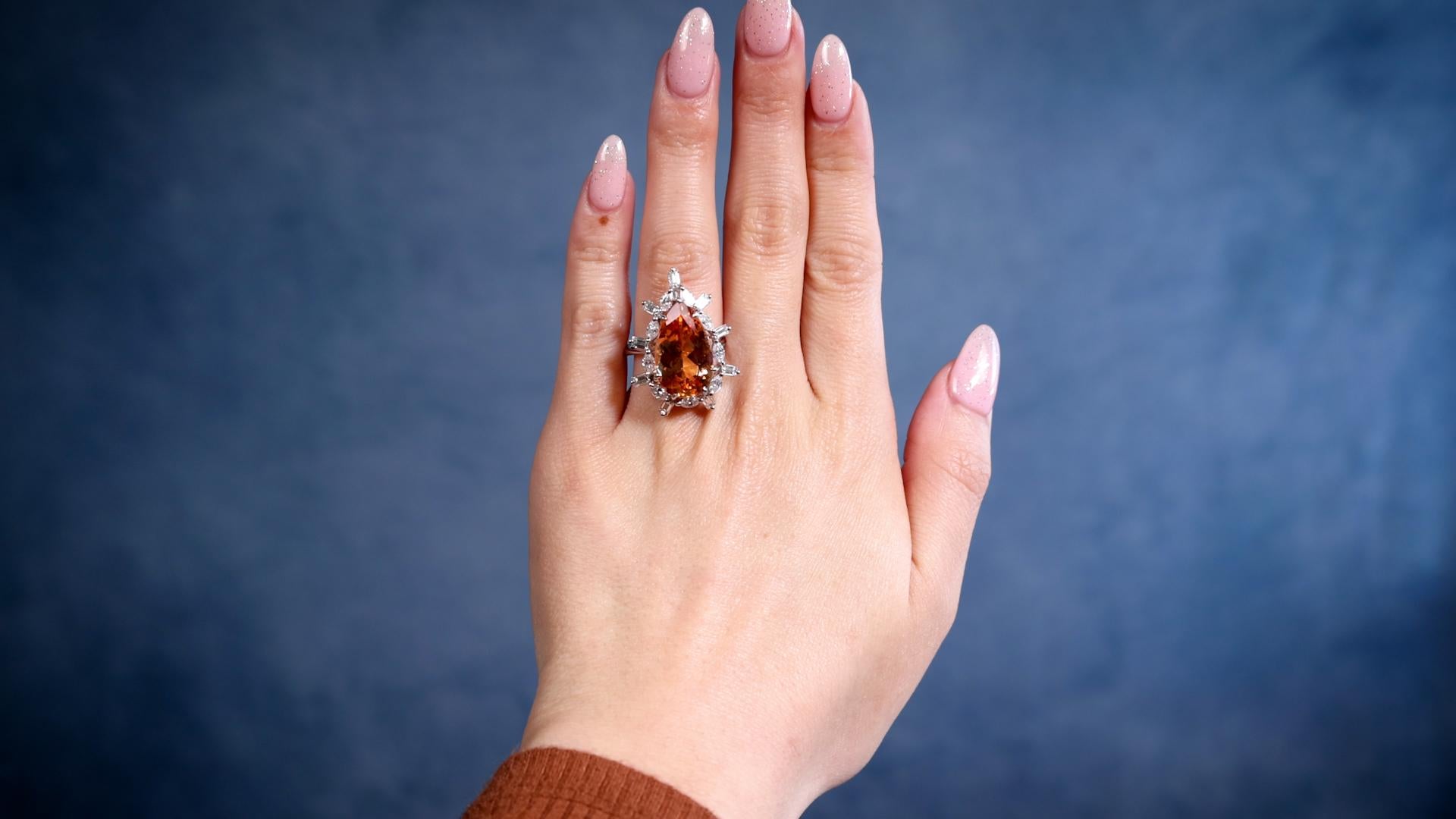One Vintage H. Stern Imperial Topaz Diamond 18k White Gold Cluster Ring. Featuring one pear brilliant cut imperial topaz weighing approximately 10.00 carats. Accented by nine marquise diamonds with a total weight of 1.00 carat, and nine baguette cut