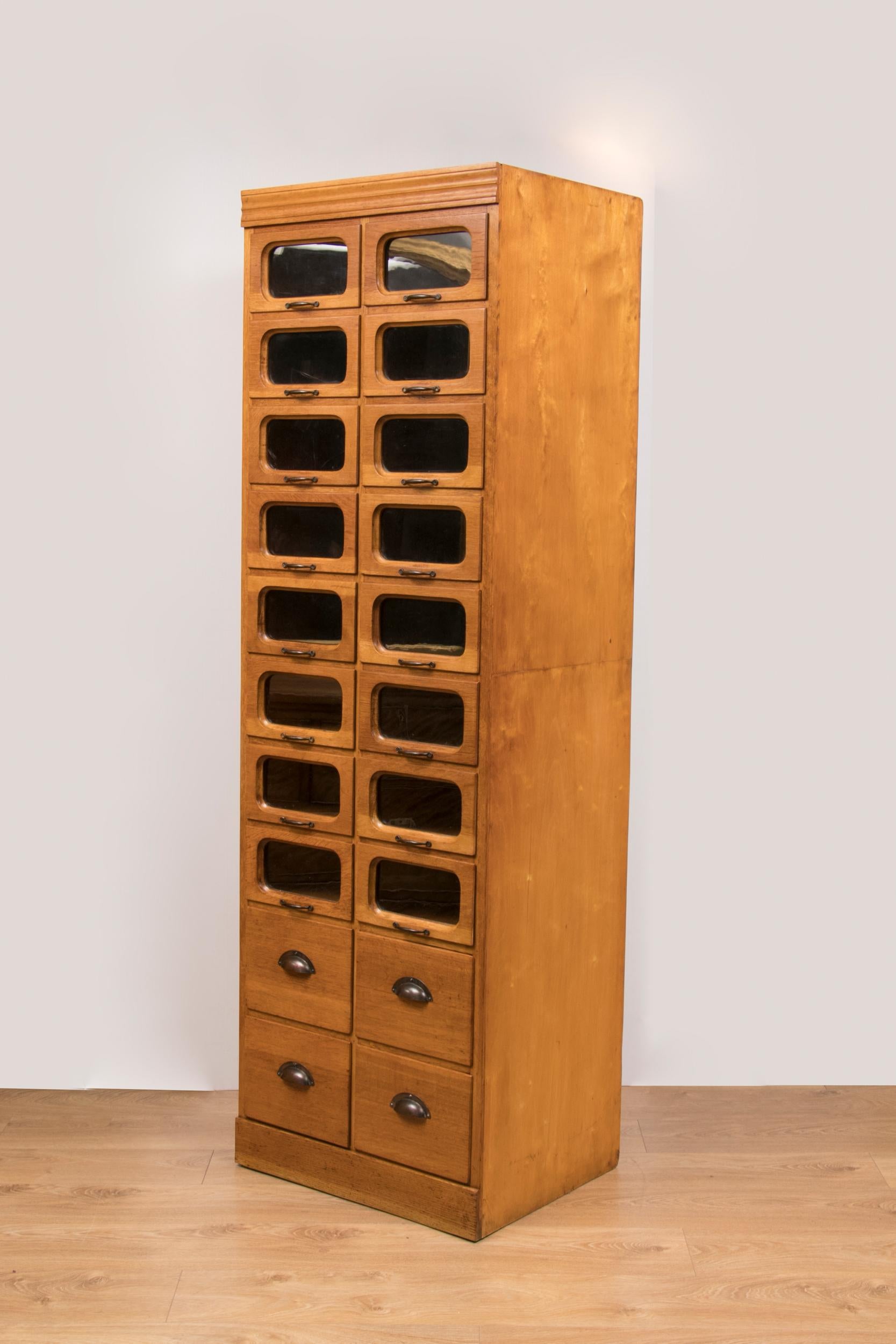 Vintage oak Haberdashery cabinet circa 1920 with 16 glass fronted drawers over 4 solid drawers.