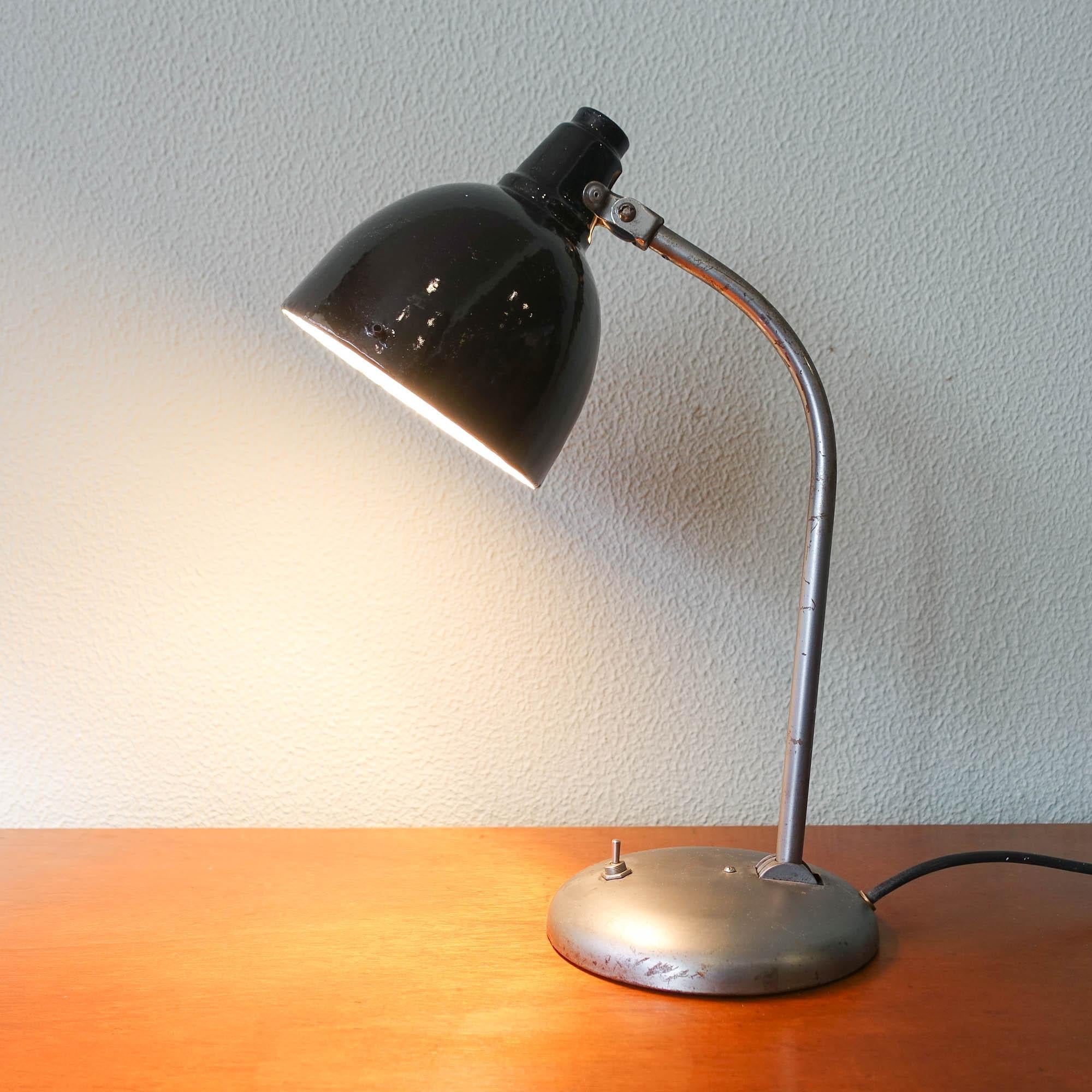 Diese Schreibtischlampe wurde in den 1930er Jahren von Hala in den Niederlanden entworfen und hergestellt. Sie besteht aus einem hochwertigen grauen Metallsockel mit einem schwarz lackierten Schirm. Der Arm ermöglicht es, die Kapuze der Leuchte und