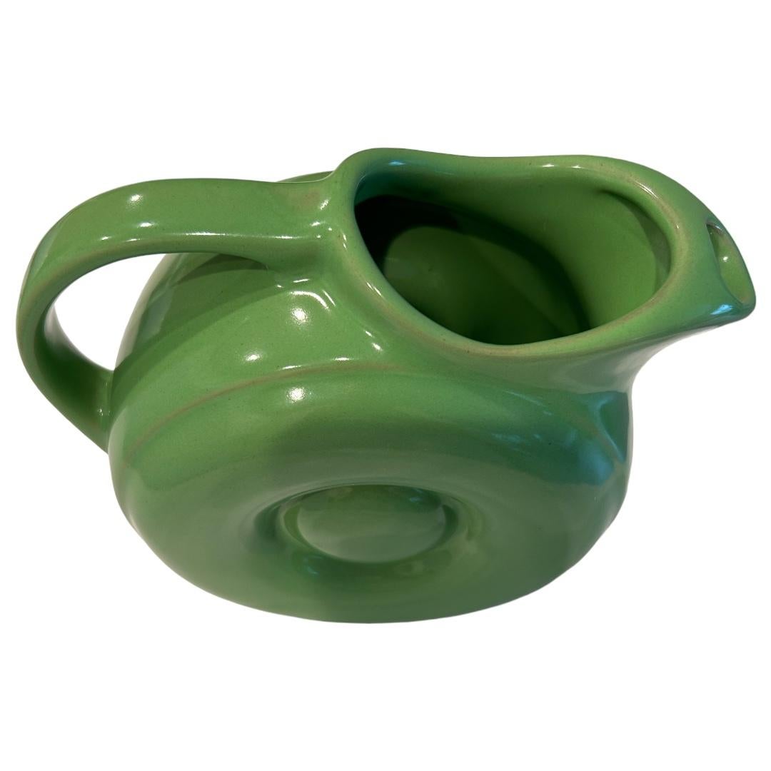 Excellent condition ~ no chips, cracks or crazing! Mid-Century Hall Pottery; solid green donut pitcher with ice lip to catch ice cubes when pouring;; fabulous addition to any table decor or collection!

9”w x 4”d x 7”h.