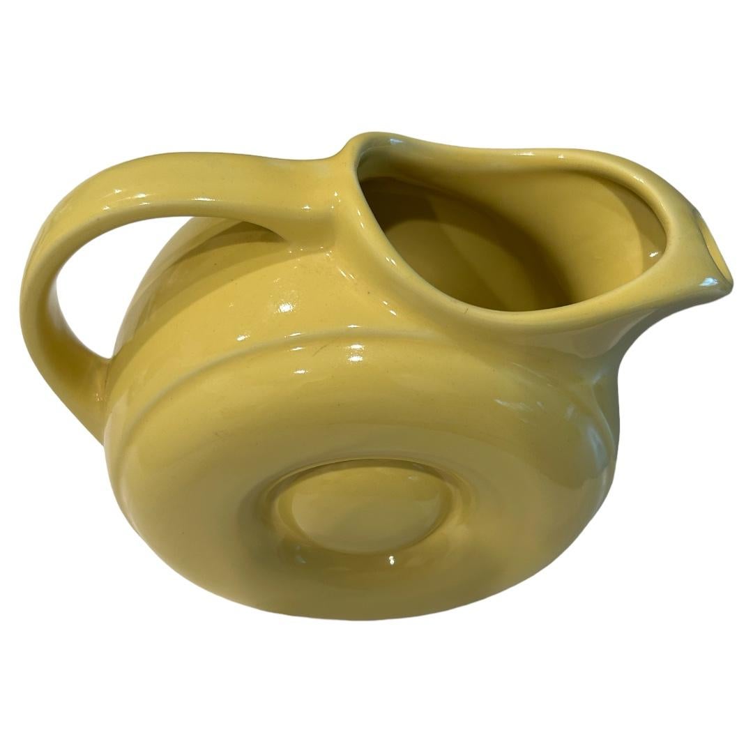 Excellent condition ~ no chips, cracks or crazing! Mid-Century Hall Pottery: solid yellow donut pitcher with ice lip to catch ice cubes when pouring; fabulous addition to any table decor or collection; made in USA

9”w x 4”d x 7”h.