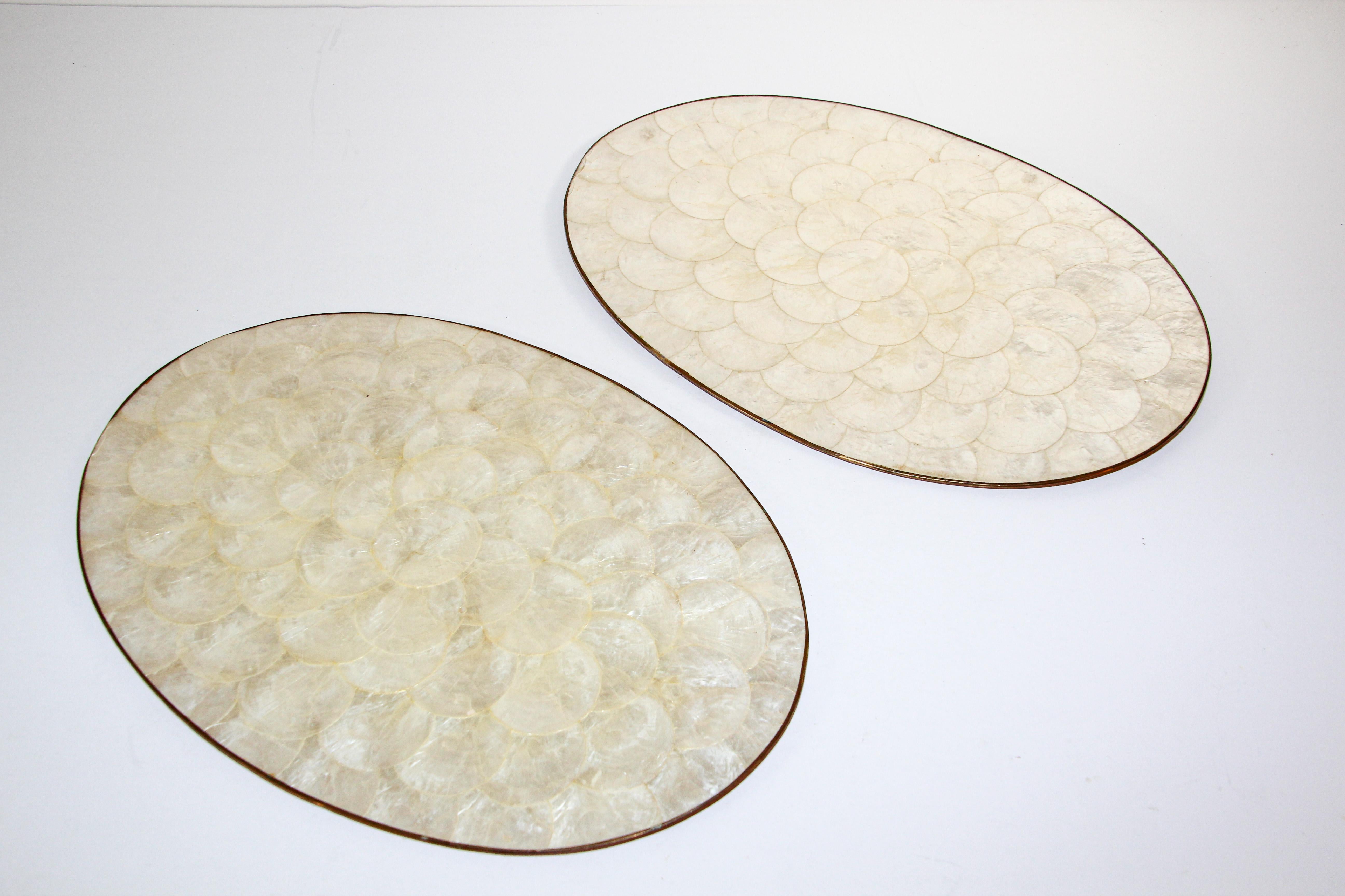 Vintage Hallie St Mary placemats, set of two capiz, abalone, pearl shell design oval placemats with brass rim.
Luminous, beautiful mother of pearl shell color.
The reverse of these placemats is cork. 
These would make a beautiful, tropical and