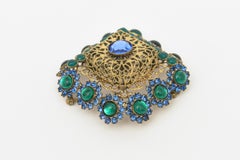 Spilla Hattie Carnegie con marchio d'epoca, metallo dorato, vetro verde e blu