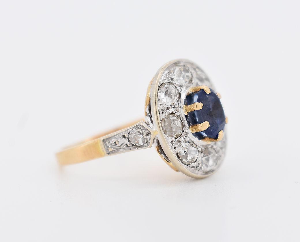Bague Halo Vintage circa 1960 en or 18 carats bicolore (jaune et blanc). Il est serti d'un saphir central ovale d'environ 1,50 carats (6 x 5 x 7,5 mm), entouré de 8 diamants taille ancienne totalisant environ 1,5 carats. Les épaules de la bague sont