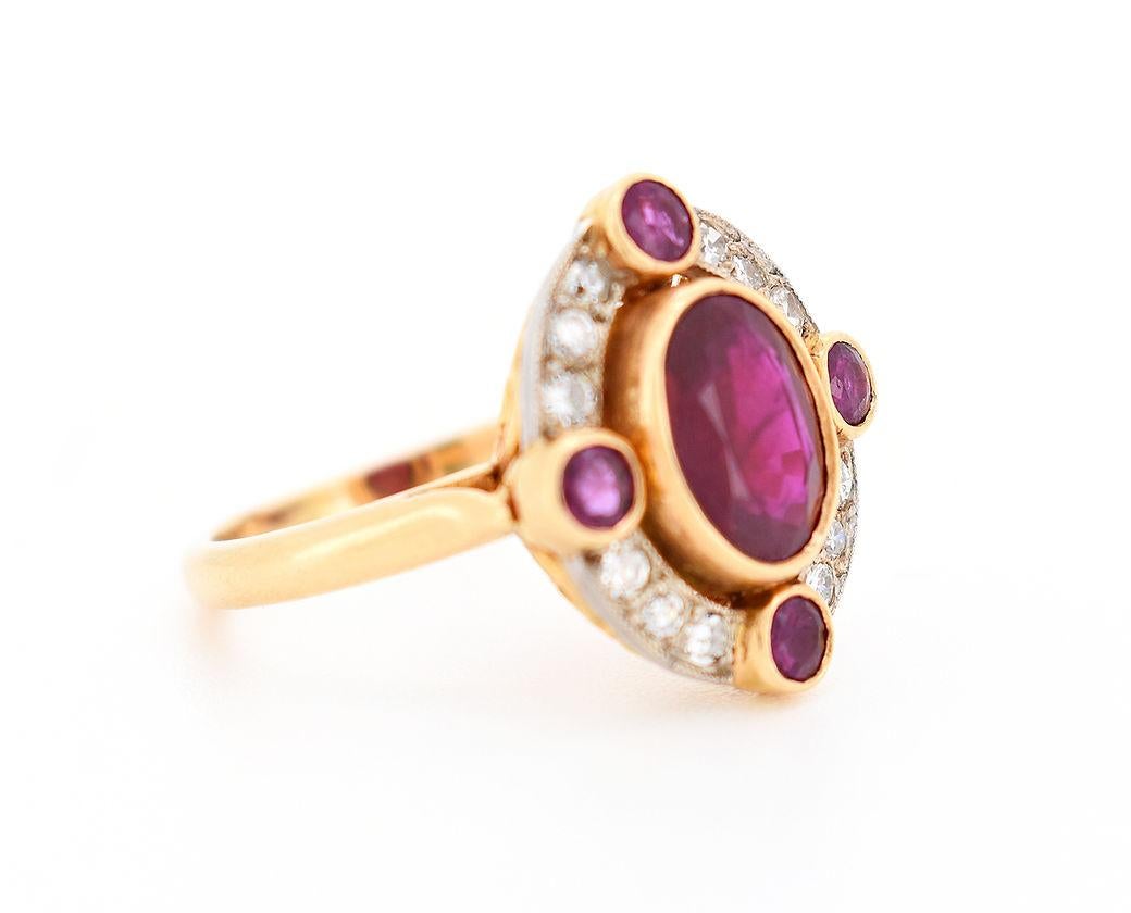 Vintage halo ring from the 1970s in 18K gold. It is centered with a natural Burmese ruby of approximately 2.14 carats, surrounded by 12 round diamonds totaling approximately 0.50 carat, and 4 natural Burmese rubies for a total of approximately 0.80