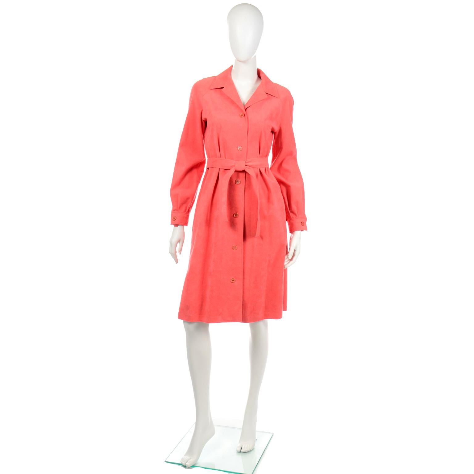 This is an original vintage 1970's Halston ultrasuede dress/coat in a beautiful salmon peach color. The dress/coat has a belt that is attached at the waist, functional pockets, a notched collar and front button opening. The cuffs of the sleeves have