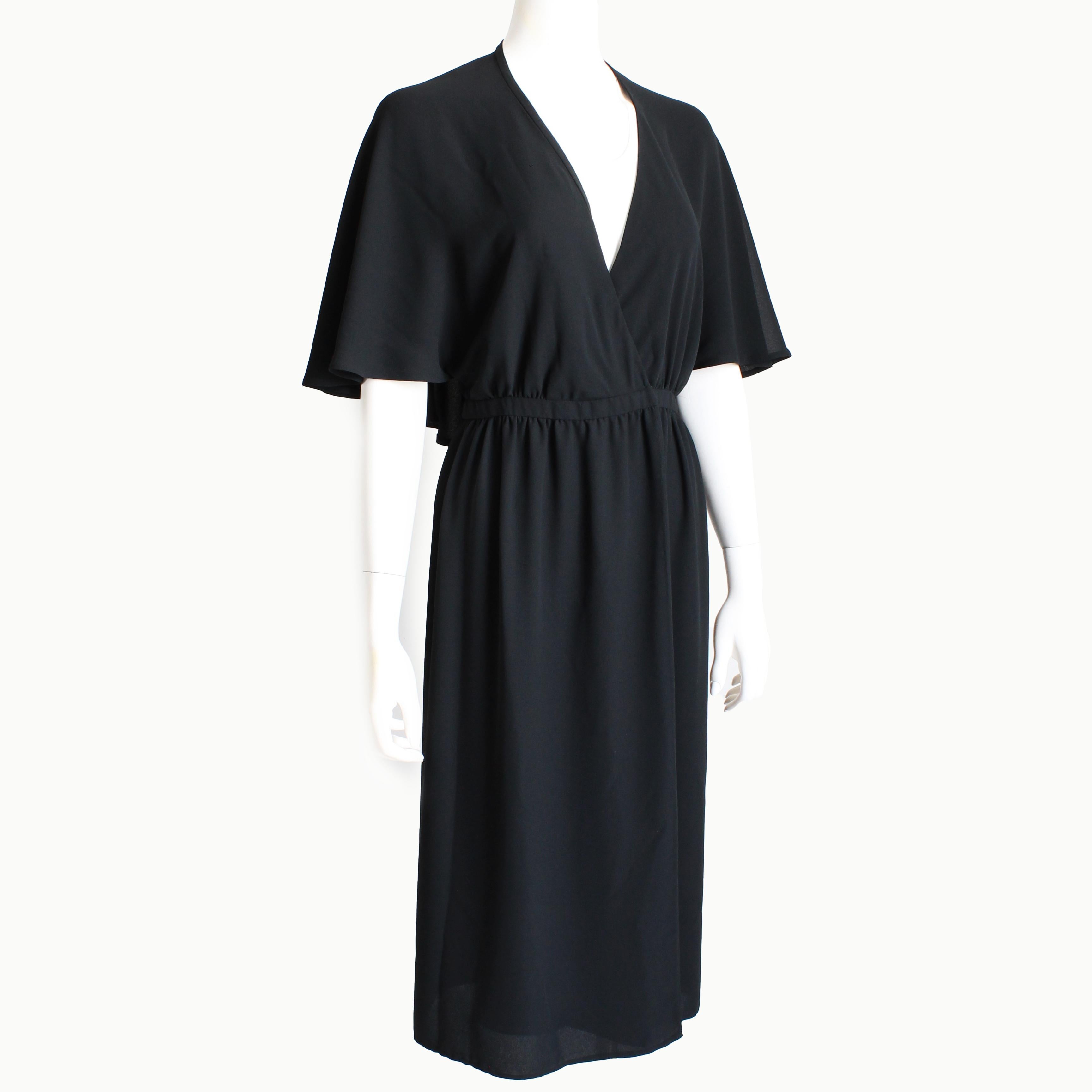Fabulous vintage Halston evening or cocktail dress, likely made in the 1970s. This chic little black dress is made from gorgeous black silk, and features a halter top with an attached flowing capelet. A true wrap dress, it fastens at the waist with