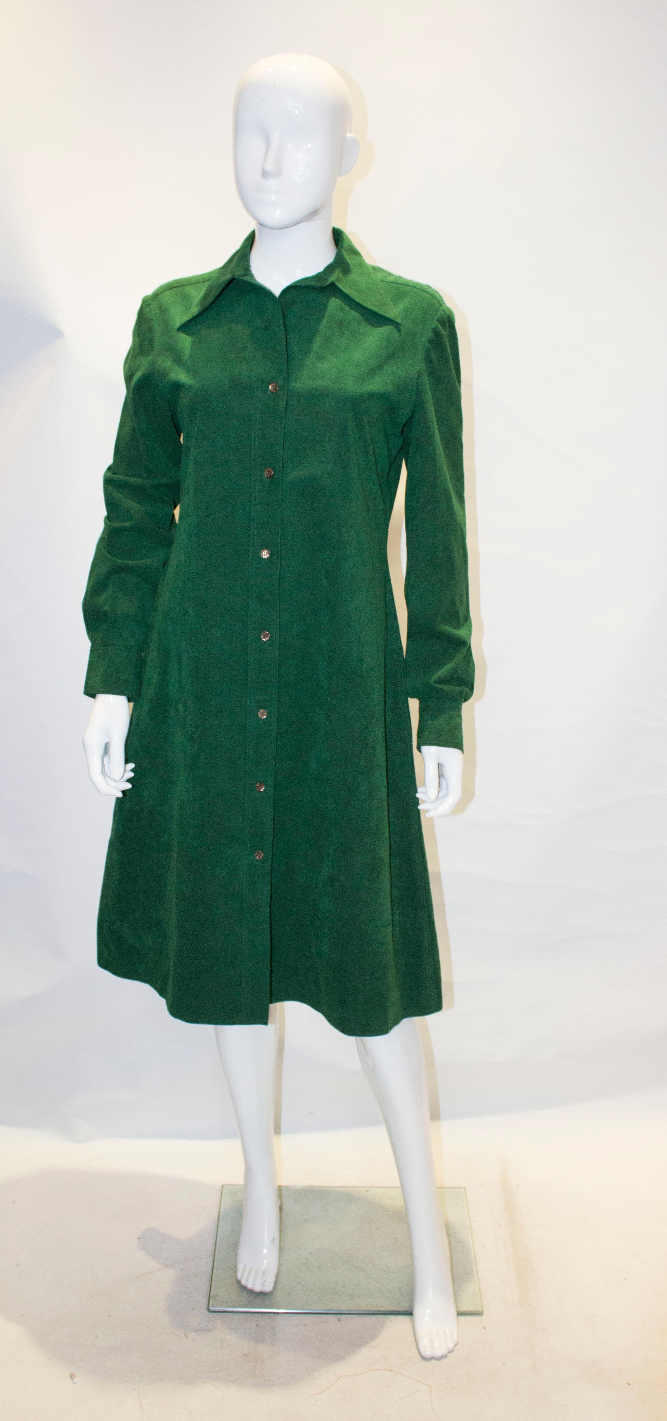 A stunning shirt dress in ultrasuede by Halston. It has a front button opening, pockets on either side and two button cuffs.