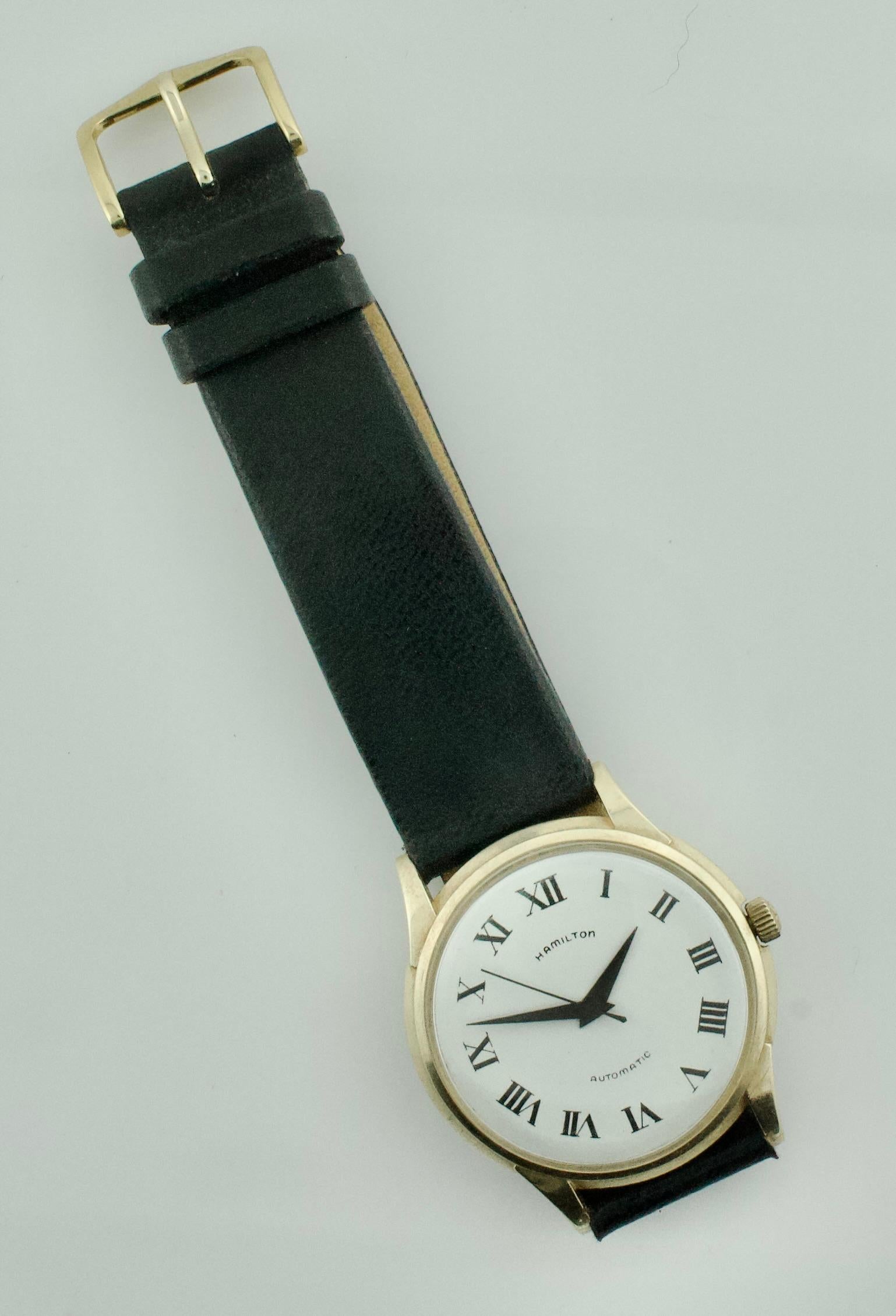 Vintage Hamilton 14k Automatikuhr CIRCA 1950er Jahre
Diese atemberaubende Hamilton-Uhr aus den 1950er Jahren ist ein zeitloses Beispiel für klassische amerikanische Uhrmacherkunst. Das 14-karätige Goldgehäuse mit seinem eleganten und schlanken