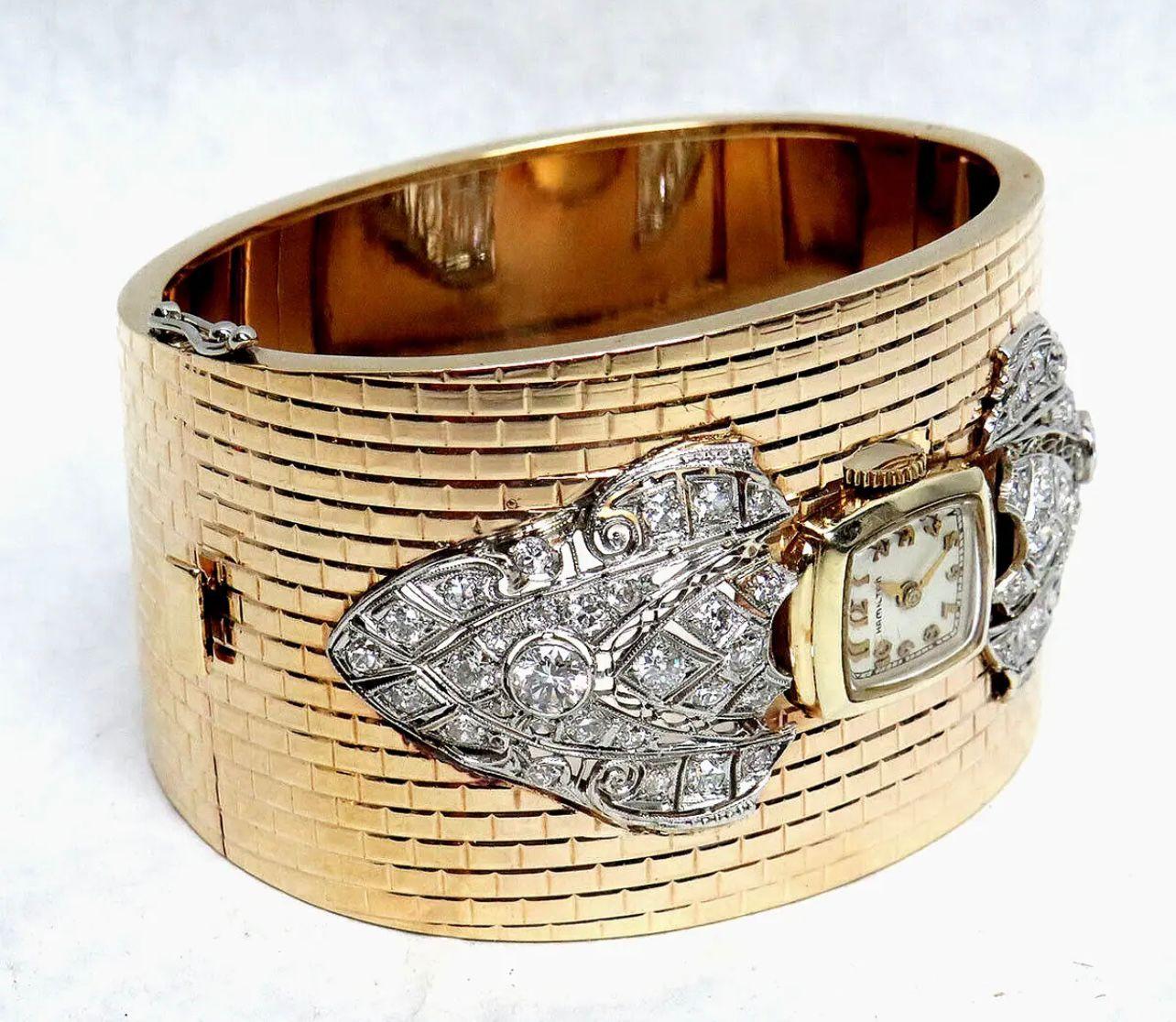 Vintage Hamilton-Uhr, eingebettet in ein Manschettenarmband aus 14-karätigem Gold und verziert mit Diamanten.
Zeitraum: 1950s
Abmessungen: 
Länge: 15 cm
Breite: 4 cm
Zustand: sehr gut. 

........Zusätzliche Informationen ........

- Das Foto kann