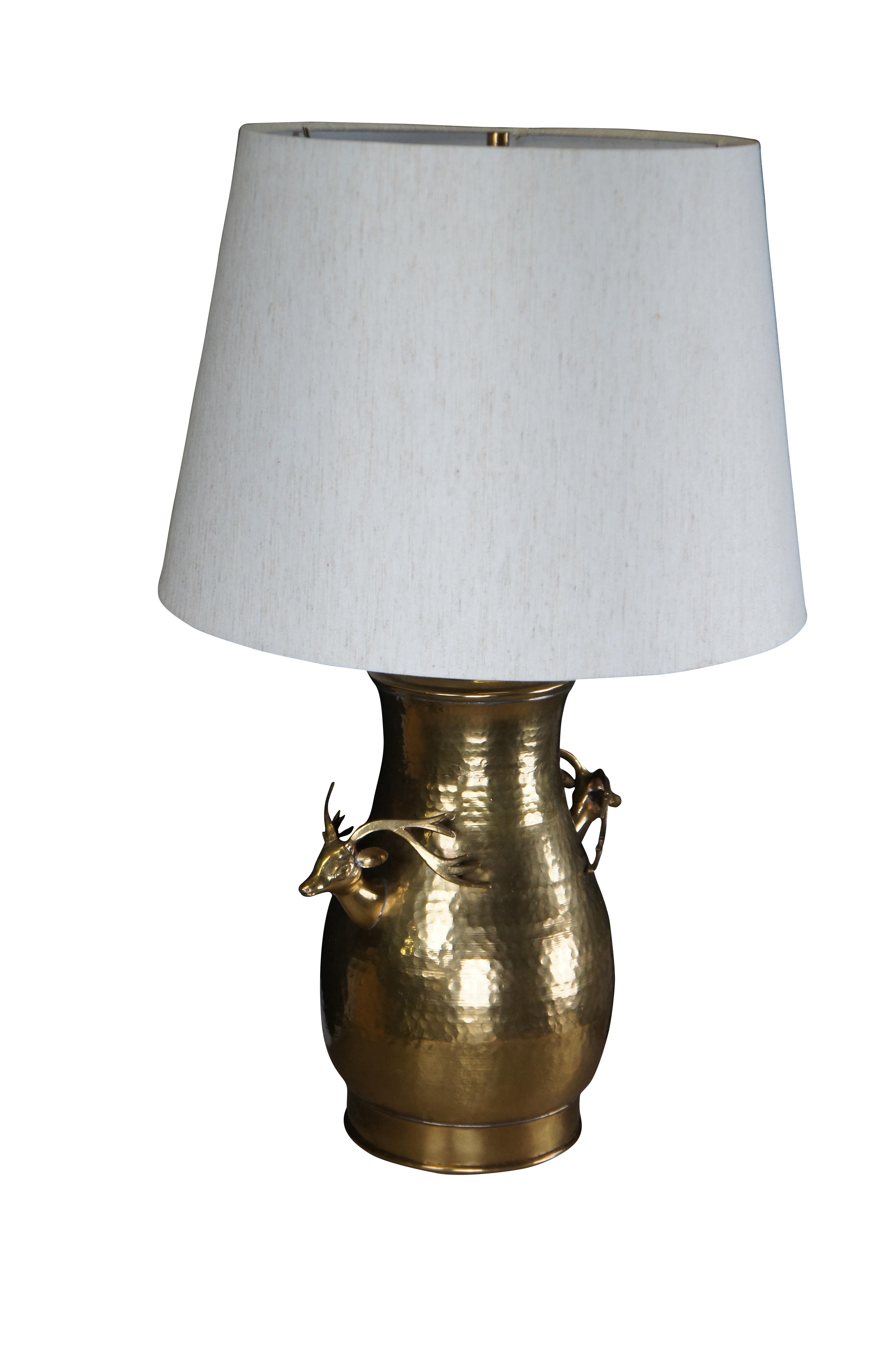 Vintage hammered brass urn or vase with stag head handles.  The vase was converted to a lamp around 1980 and includes a shade.  

Dimensions:
27