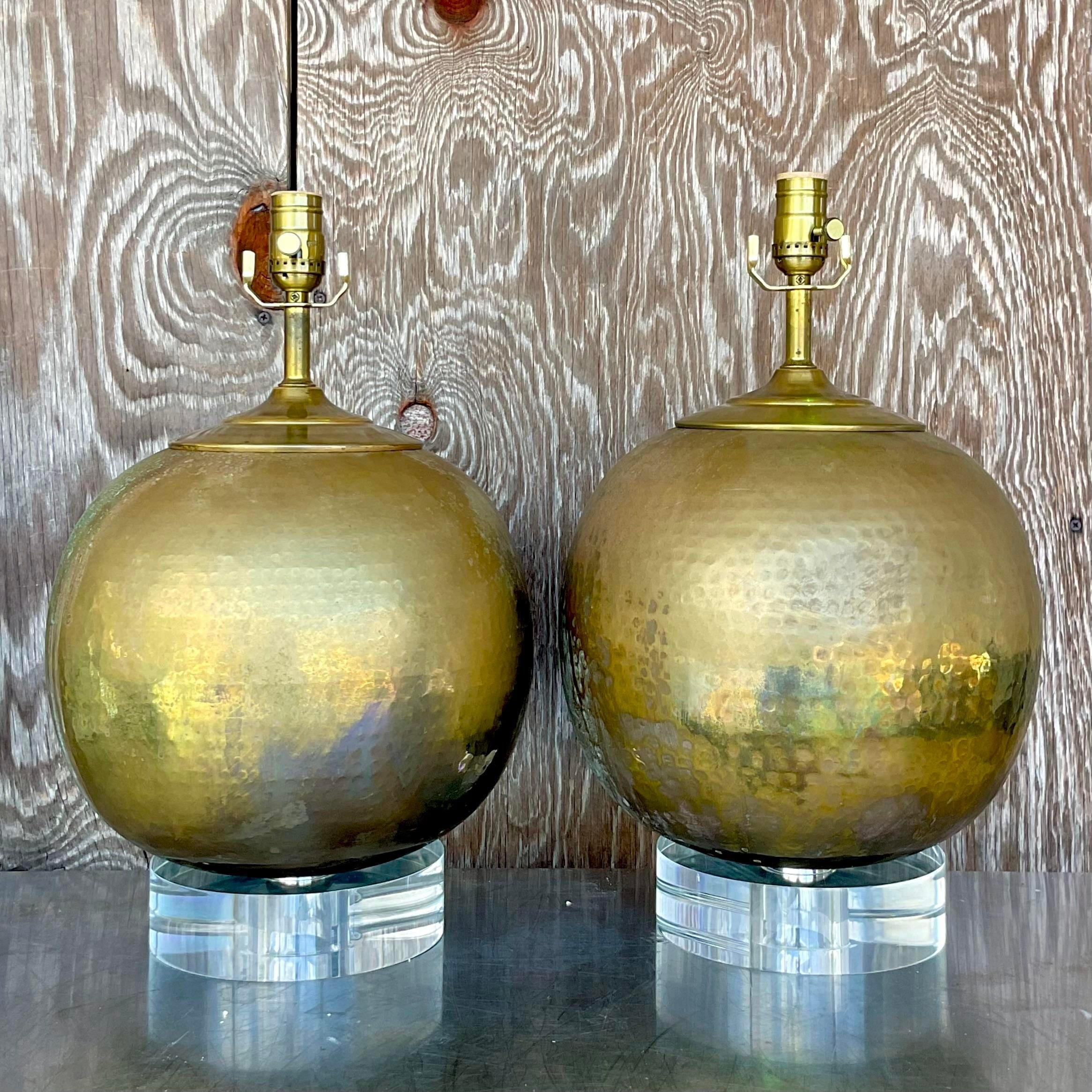 A fabulous pair of vintage hammered brass lamps. A chic sphere shape resting on a heavy lucite plinth. Fully restored with all new wiring, hardware and plinths. Acquired from a Palm Beach estate