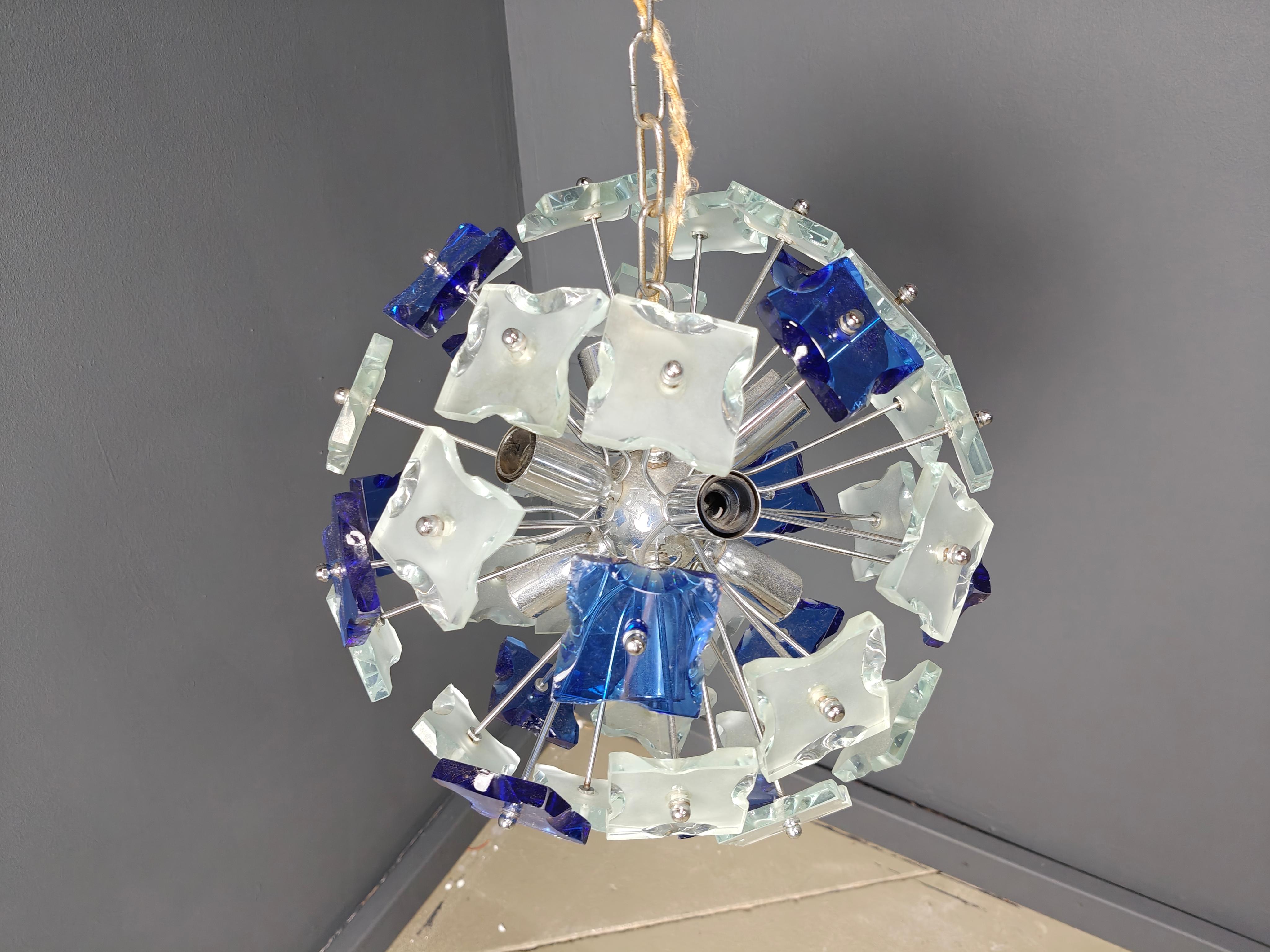 Striking sputnik shaped chandelier with blue hammered glass glasses mounted on a chrome frame.

Once illuminated, this beautiful chandelier emits a warm diffuse light.

Tested and ready to use.

We can change the chain length if desired.

Works with
