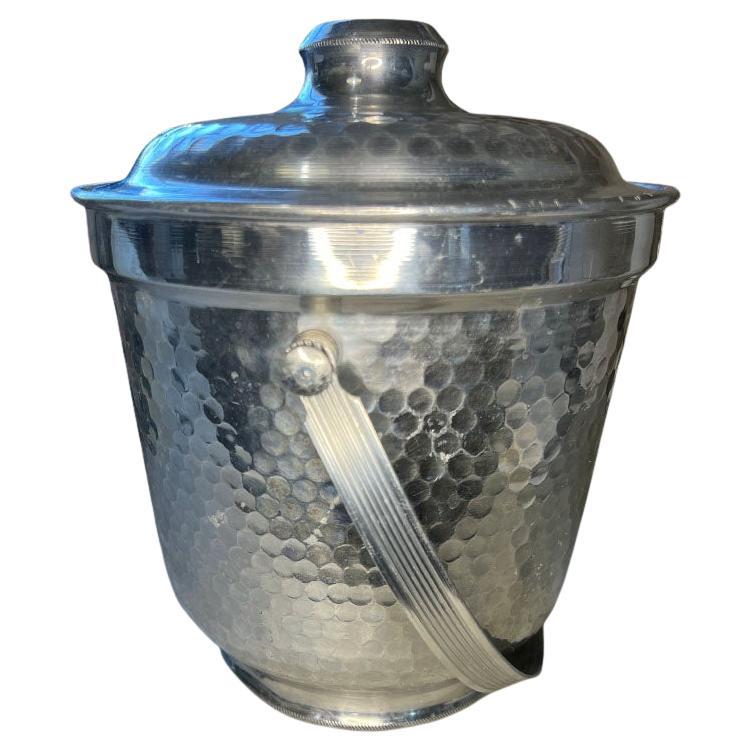 Un secchiello per il ghiaccio vintage italiano Hollywood Regency o Mid-Century Modern con coperchio. Questo secchiello in metallo sarà perfetto per il bar della tua prossima festa! È rotonda e realizzata in metallo. Il corpo del vaso è martellato su