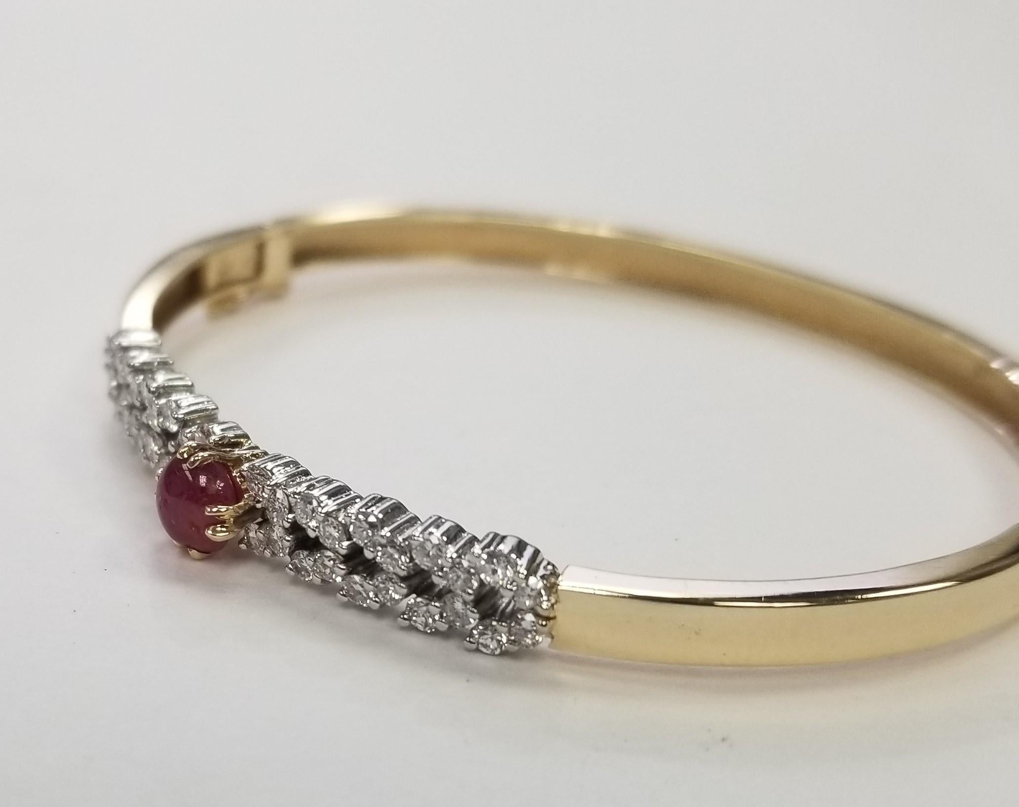 Vintage Hammerman Brothers 14k Yellow Gold Ruby and Diamond Bangle 1.00 cts.  The bracelet is hand made from flat stock with a concealed sap/box clasp and figure eight safety catch, opposite the hinge. This bracelet feature I Cabochon Ruby 1.07cts.