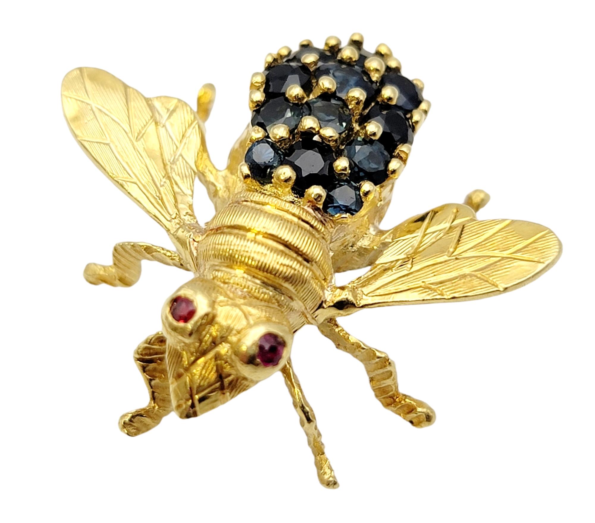 Beautifully detailed bee brooch accented with glittering sapphire and ruby accents. Made of solid 18 karat yellow gold, this exquisite vintage piece from the Hammerman Brothers is a work of art and a fantastic conversation piece. 2 natural red