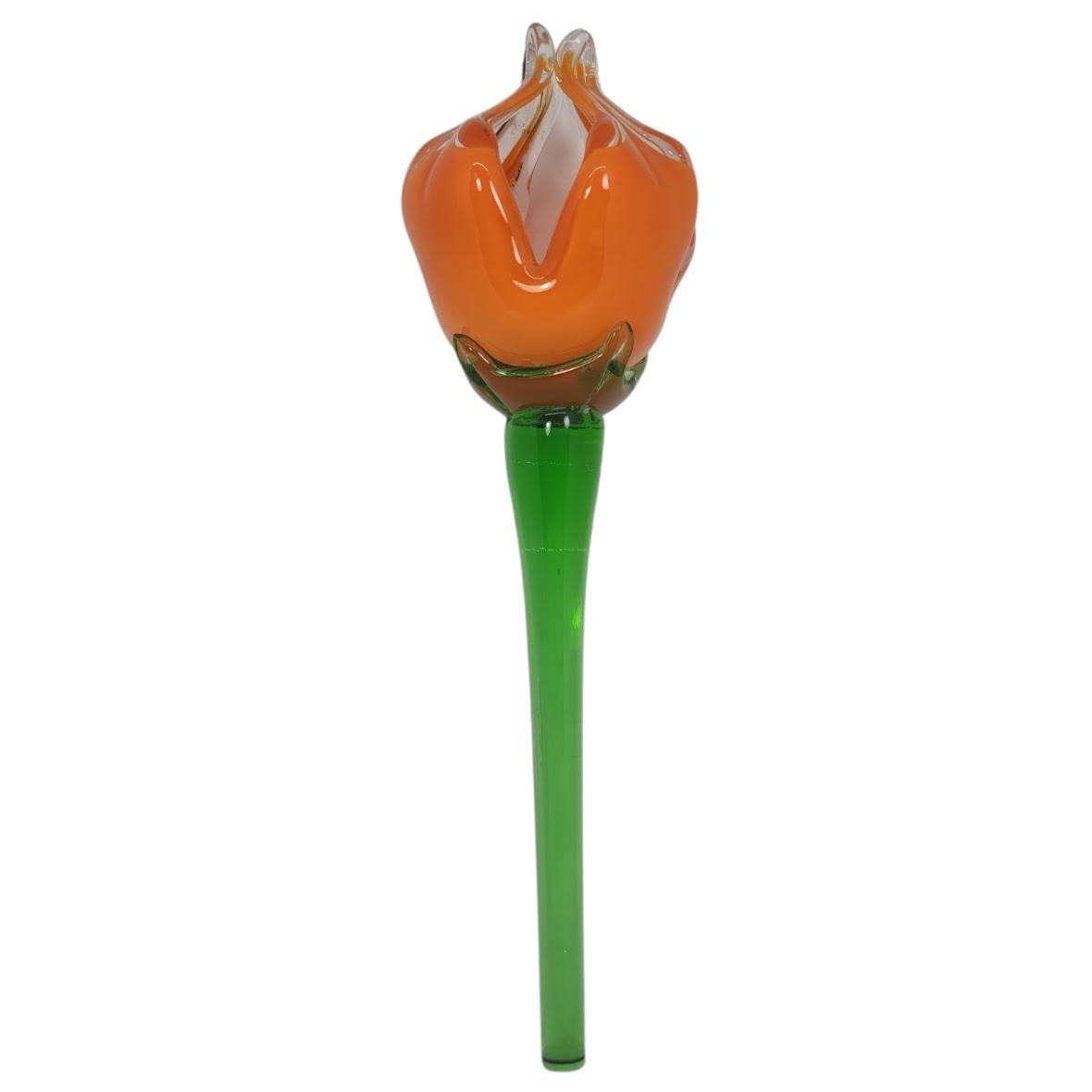 Add a touch of vintage charm to your home decor with this beautiful hand-blown glass flower. The orange flower design is adorned with a floral pattern, making it a perfect addition to your mid-century modern style collection. The decorative glass