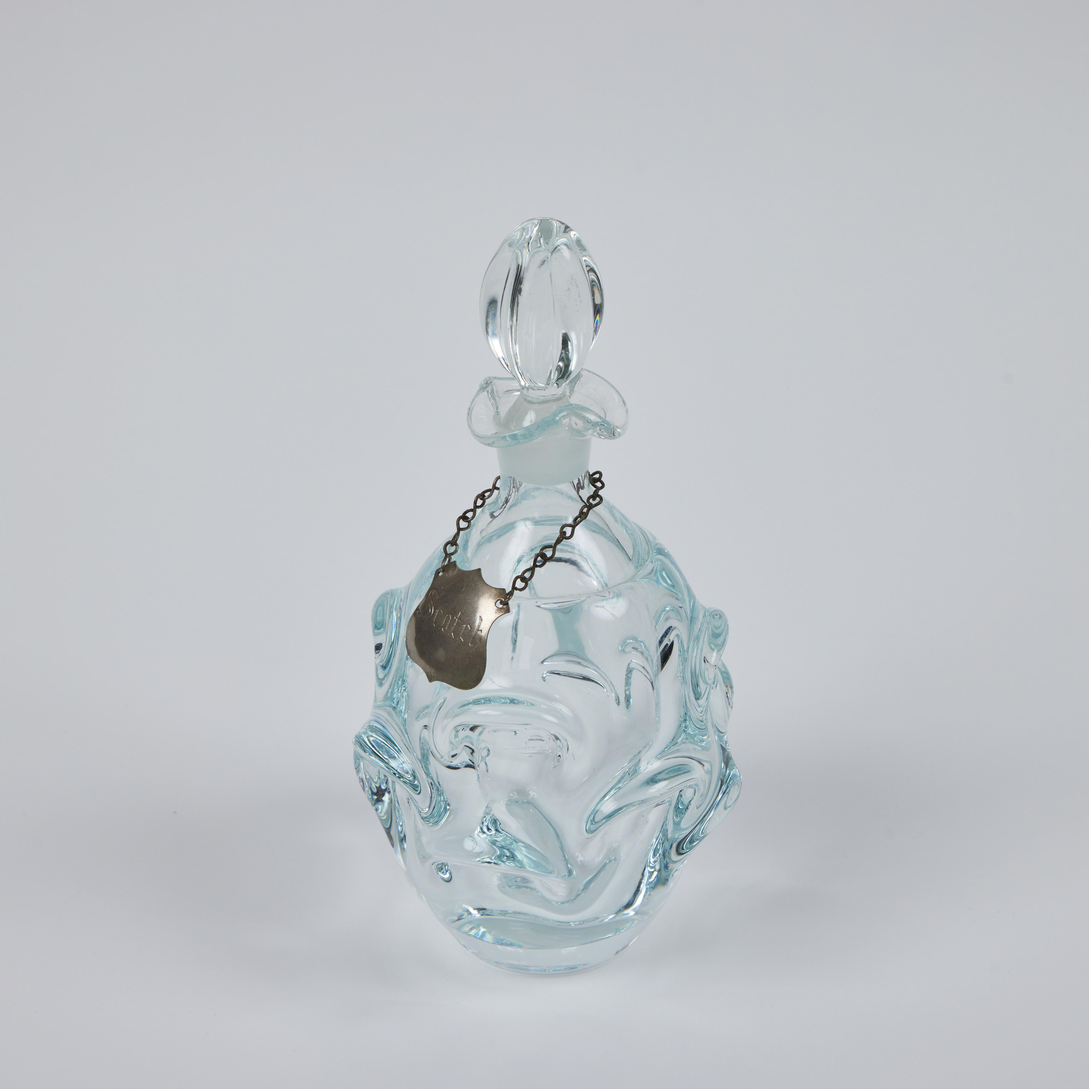 Nous avons cette belle carafe vintage en verre de Murano soufflée à la main avec un motif de pincement qui attire l'attention. L'étiquette de la carafe Scotch en métal suspendue ajoute une touche d'élégance et de formalité.  Une belle façon