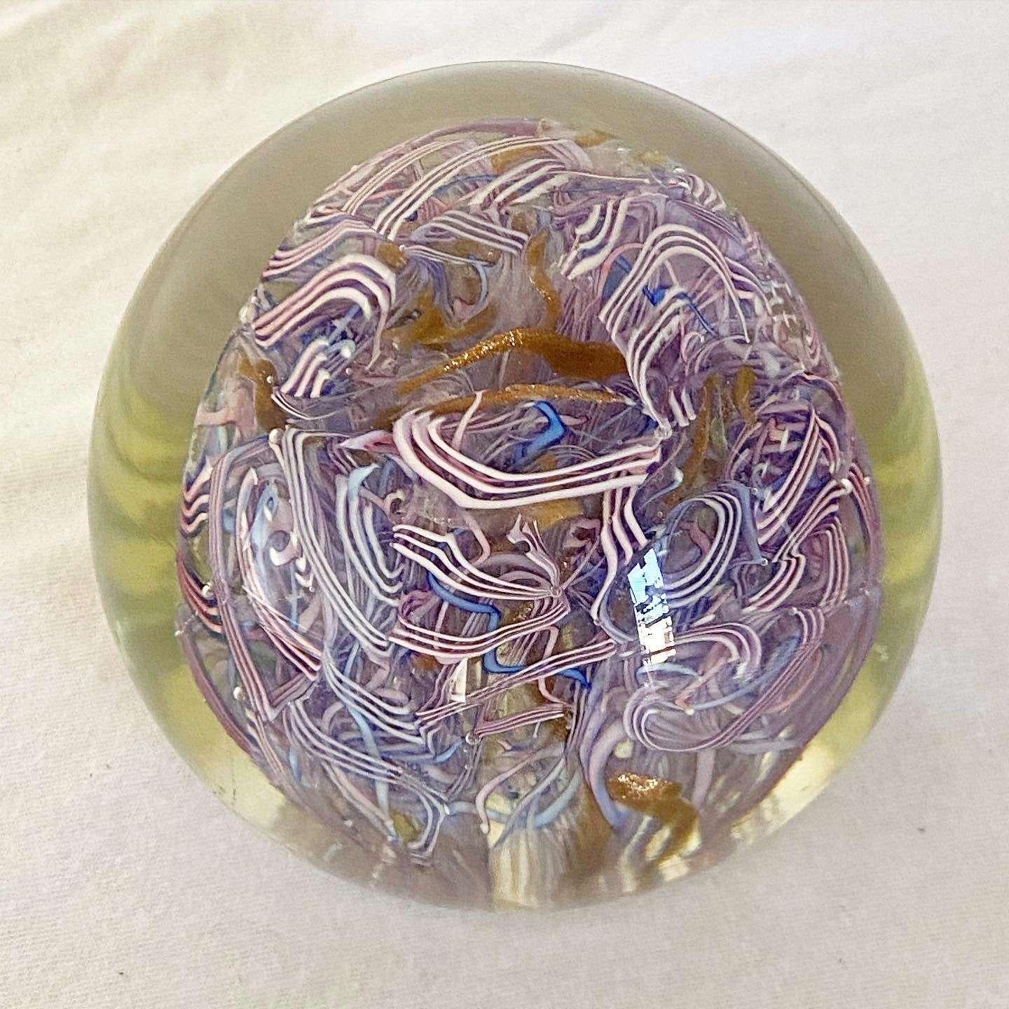 Exceptional vintage hand blown paperweight. Features a swirled purple and pink interior.

