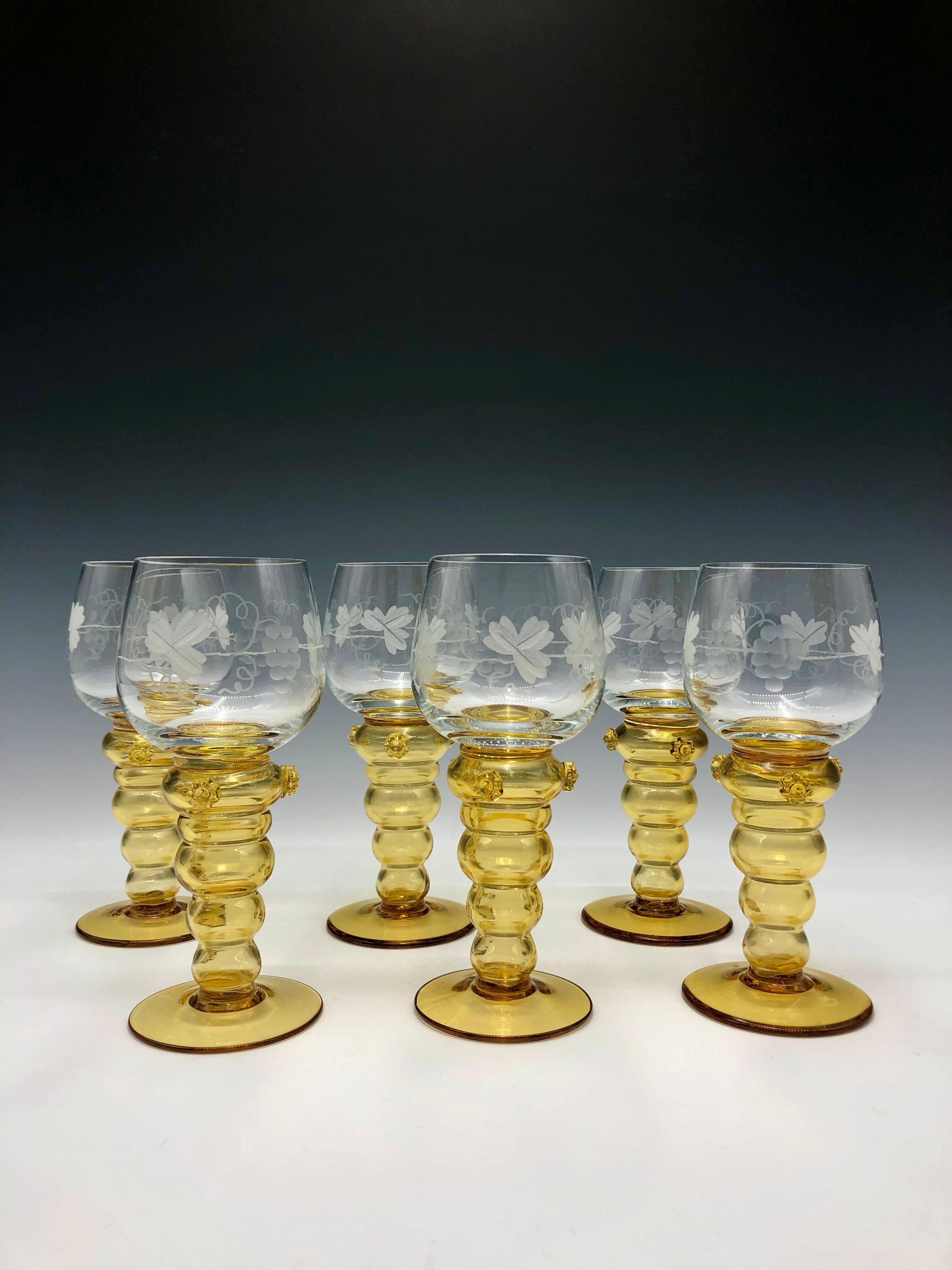 Set of six hand-blown decorative Theresienthal Roemer wine hock/glasses manufactured in Germany between 1880-1900. The clear glass is decorated with etched grapes, leaves & vines. The amber glass stems include three applied daisy-shaped glass punts