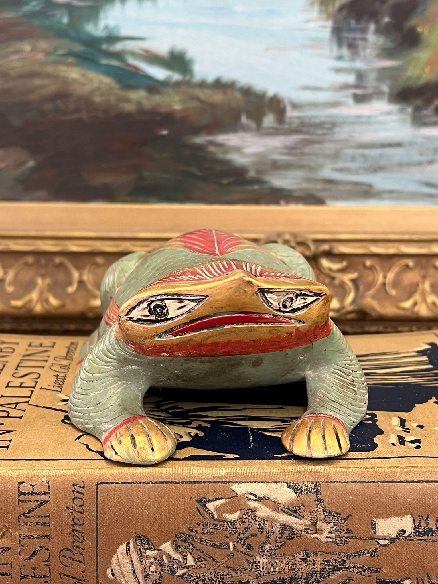 This vintage Figurine depicts an intricately carved and painted frog. It is gold toned and engraved on the bottom. This Piece has nice patina and character. Possibly folk art. Vintage Condition as pictured. Listing is for described item only. ( Box