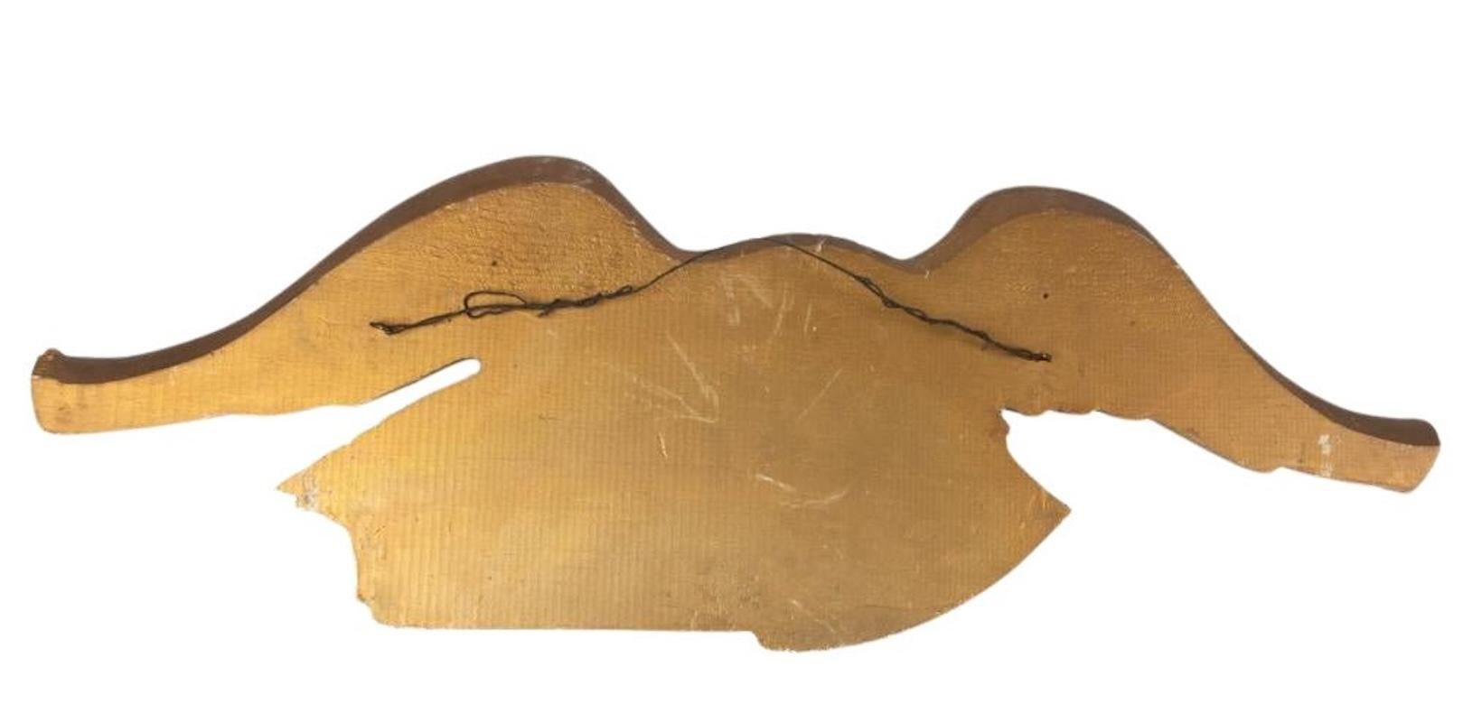 Presented is a beautiful folk art carved and painted spreadwing eagle. This early 20th century wood eagle is gilt-brushed with a painted red, white, and blue shield. It supports a shield in its right talon as the head looks to its left. In its left