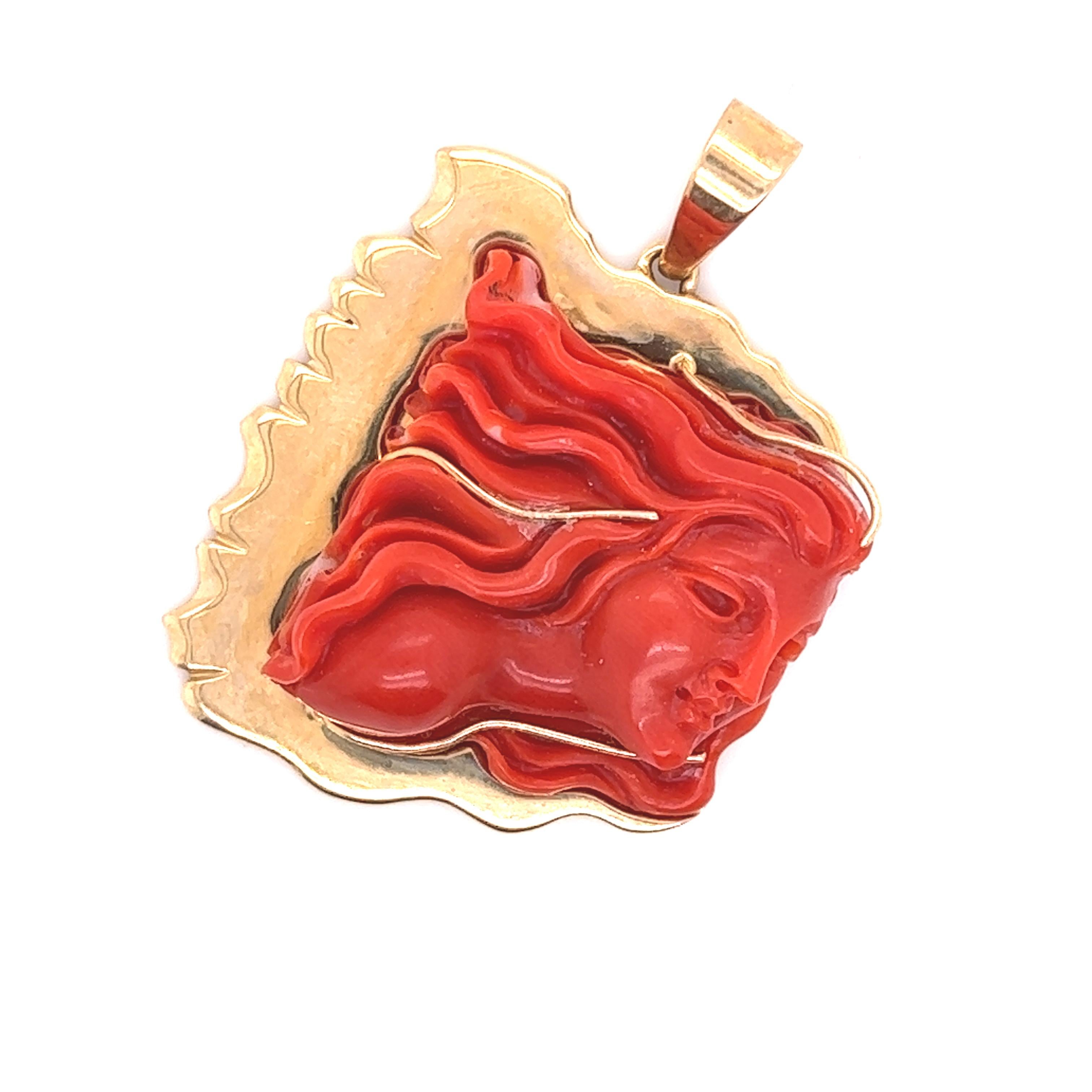 Beautiful vintage design crafted in 14k yellow gold. This pendant highlights one beautifully hand carved coral gemstone. The coral gemstone display's a vibrant red color and is beautifully carved in the form of a woman with long flowing hair. The