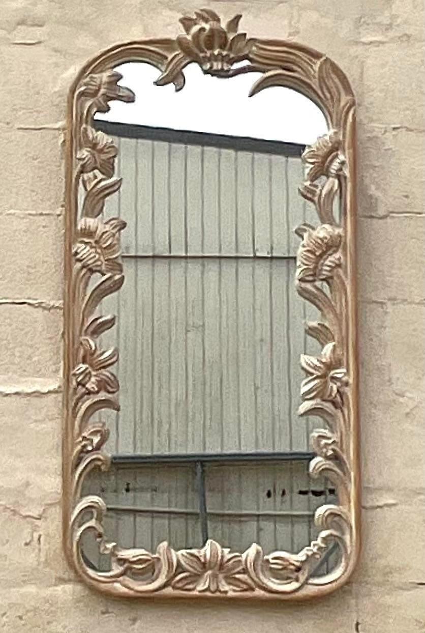 A beautiful vintage hand carved floral design wooden wall mirror. Acquired at a Palm Beach estate.