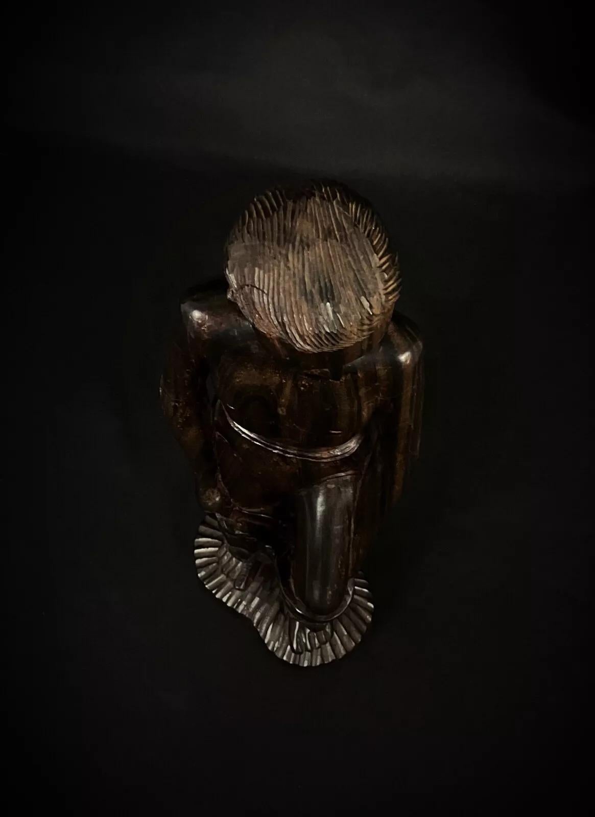 Diese handgefertigte madagassische Skulptur aus Palisanderholz ist ein schönes Zeugnis der künstlerischen Traditionen Madagaskars. Dieses Stück mit einer fein geschnitzten männlichen Figur stammt aus den Jahren 1950-1969 und zeugt von exquisiter