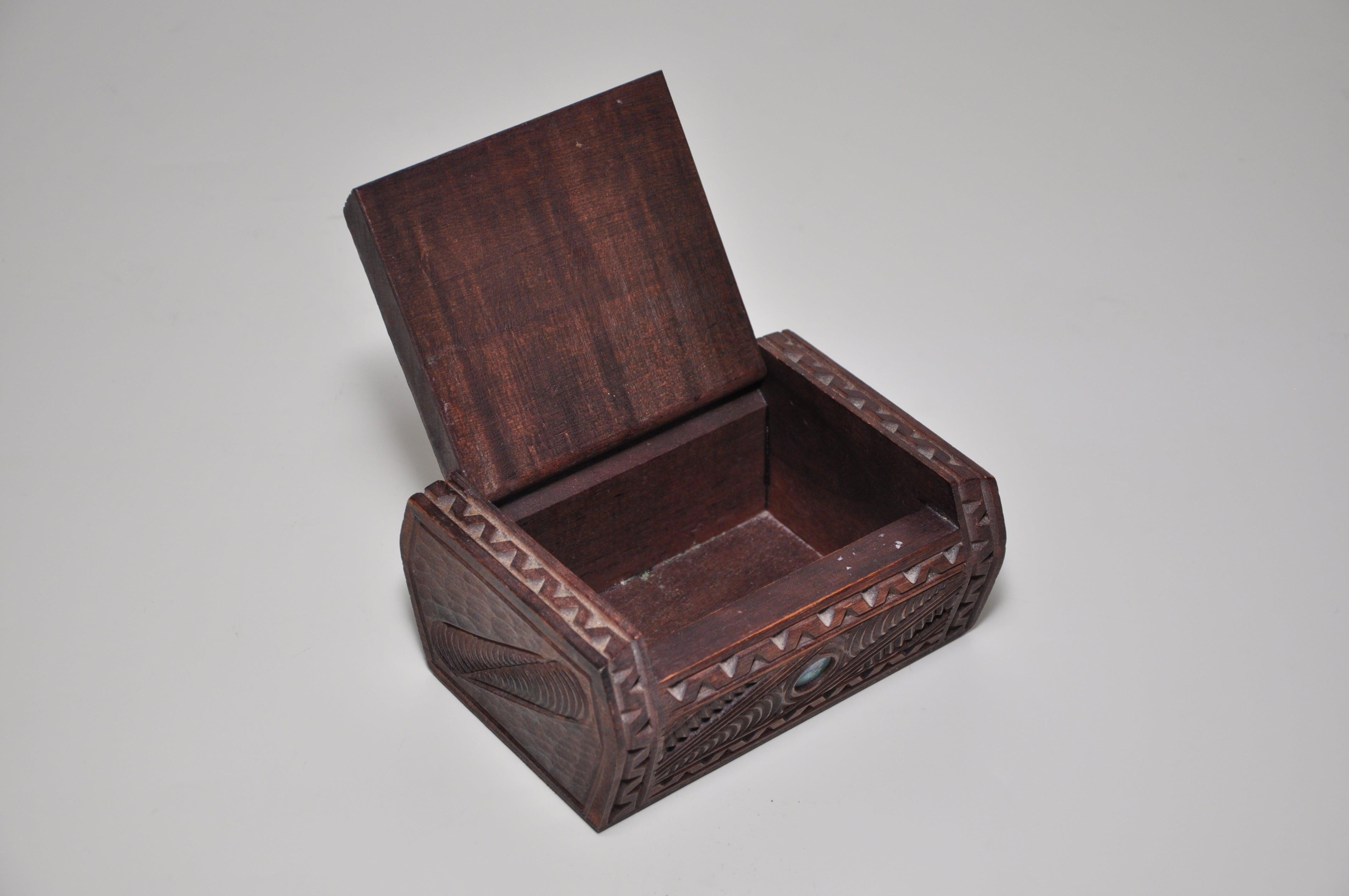 Vintage hand carved shell eyes wooden box, a vintage hand carved and inlaid dark wooden trinket or jewelry box decorated with a Maori tribal face and inlaid paua shell ‘eyes’ on the pin-hinged lid, with other incised motifs to the sides. This is an