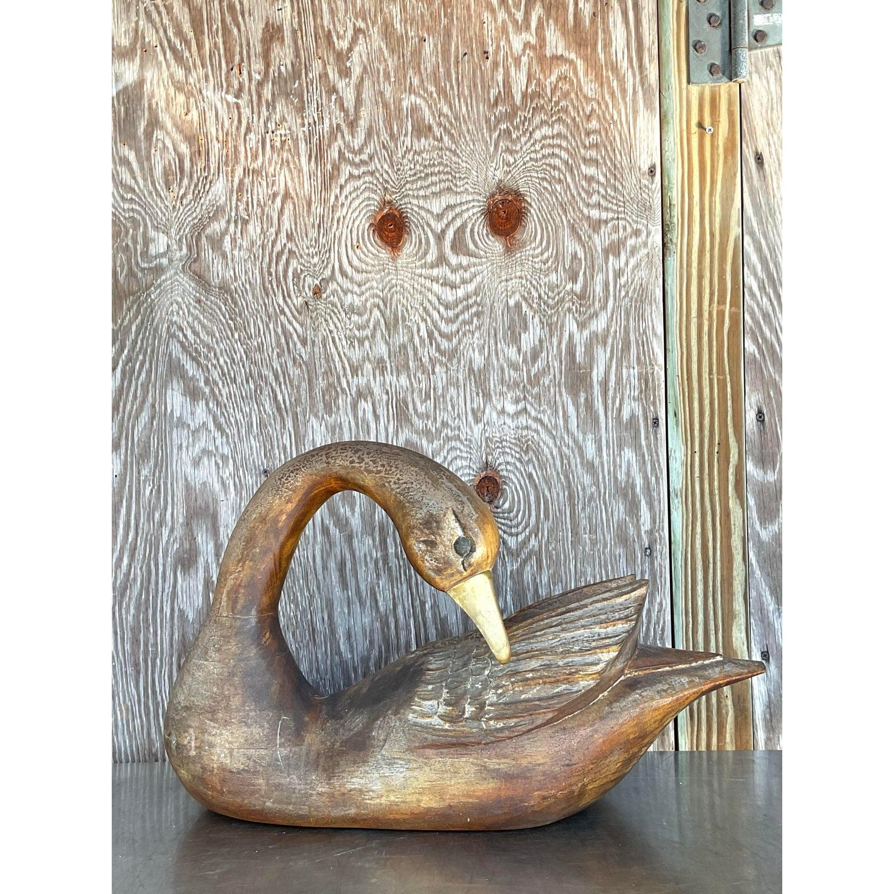 This stunning vintage hand-carved wooden swan sculpture exudes timeless elegance with its graceful curves and intricate detailing. Crafted from solid wood, the piece features a rich, warm patina that enhances its rustic charm, while the brass beak