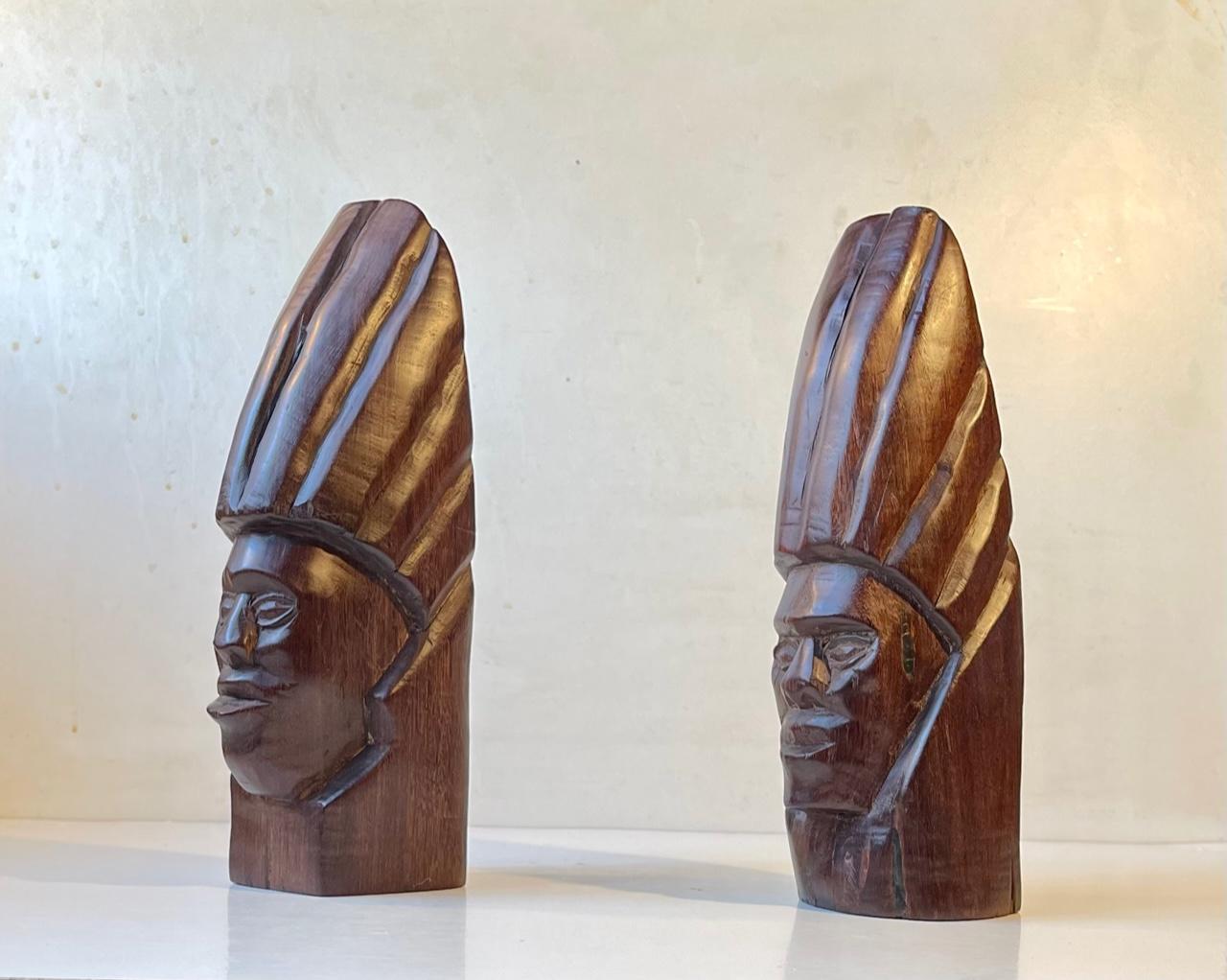 A set of heavy wooden bookends hand-carved with primitive tools. Both carved from one piece of wood. Slight differences in appearances/design. Precise origin unknown. Brought home by a Danish Traveler circa 1970. Measurements: H: 29/27.5 cm, W: