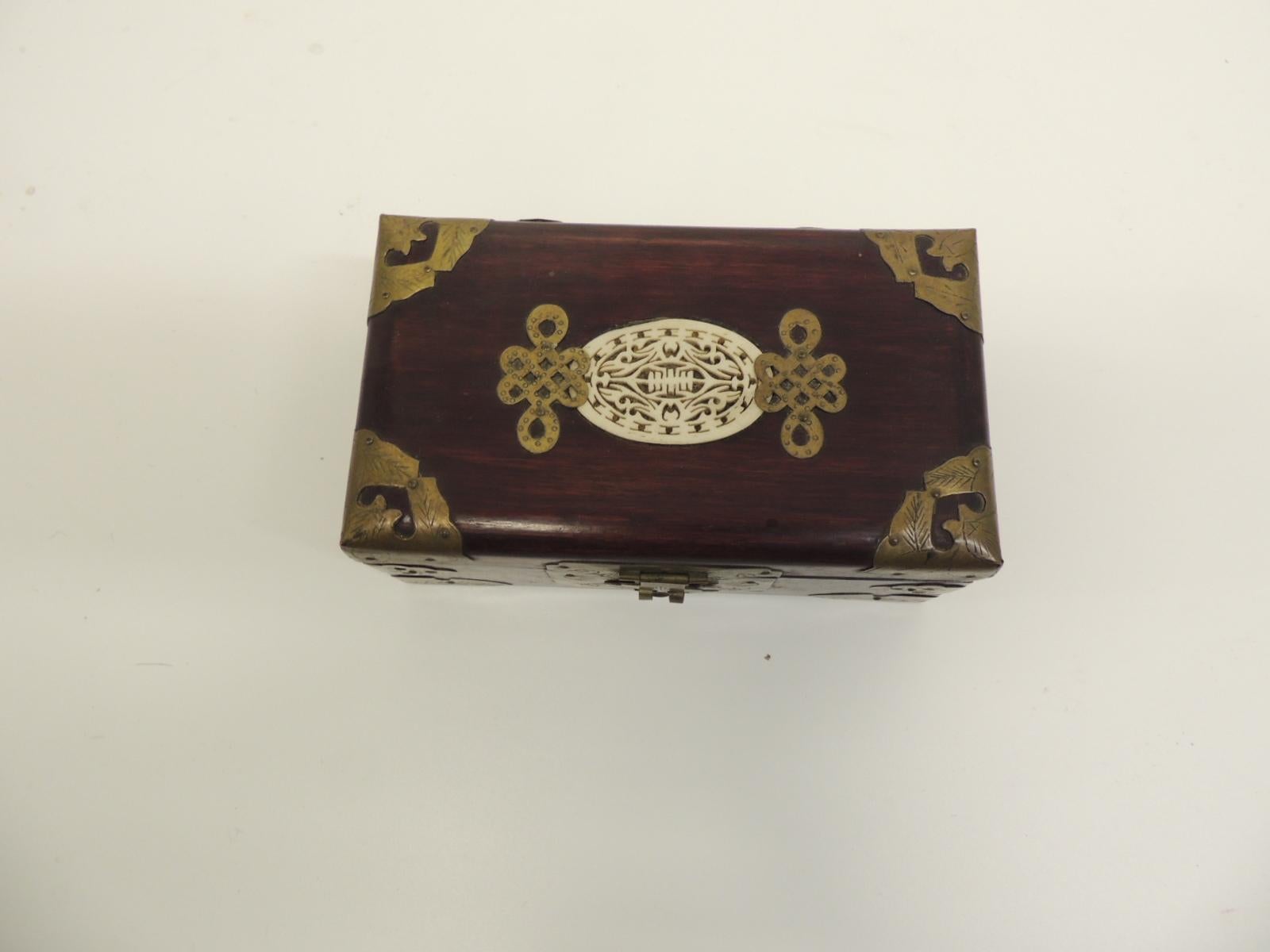 Vintage hand carved wood and bone Asian jewelry box.
Inside compartments are lined with woven silk textile depicting a village scene.
The wood case has a carved bone medallion and brass fittings all around.
In shades of gold, green, blue and