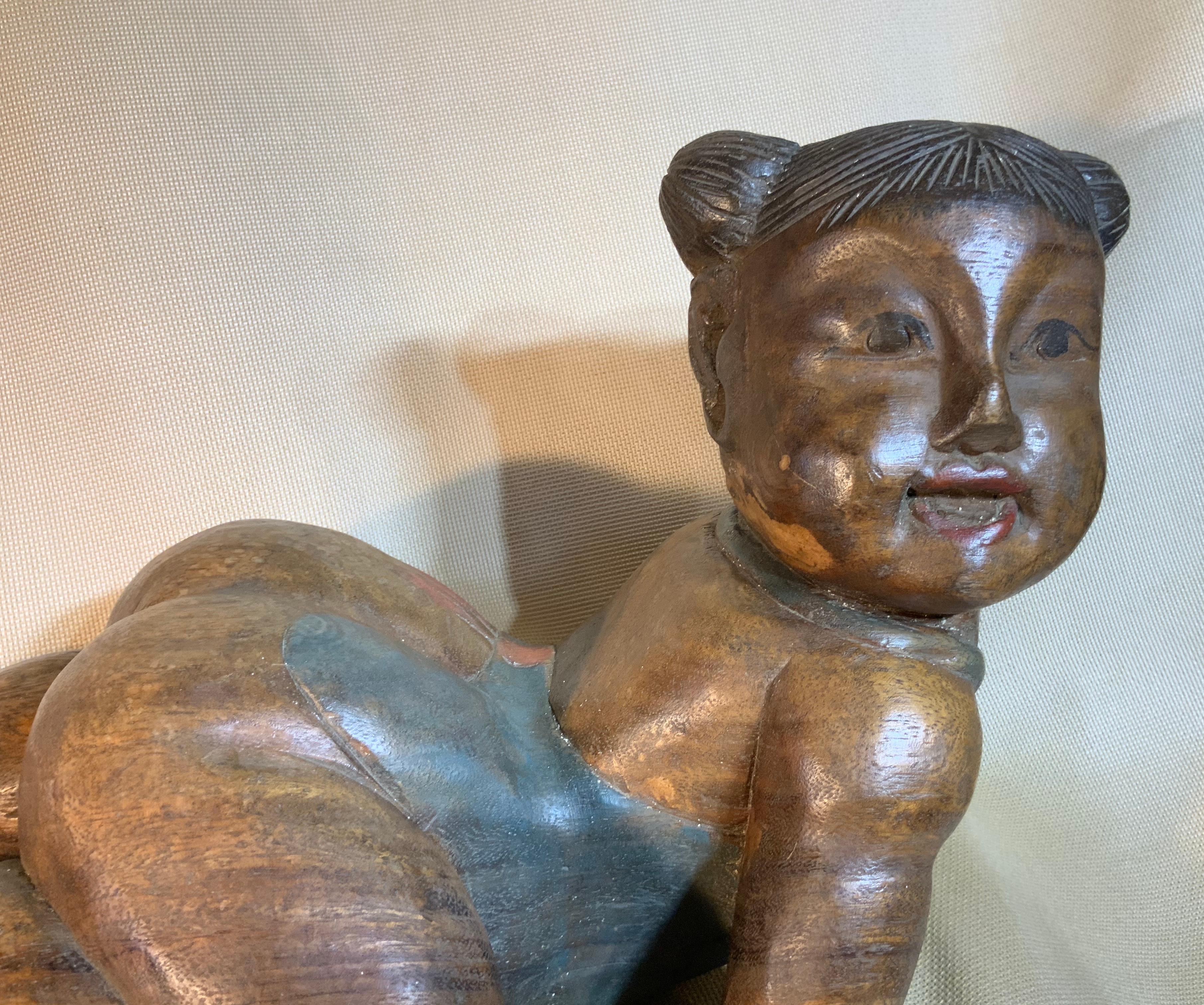 Elegant laying down wood statue of baby girl gentle facial expression
with two piggy tail, originally painted in some parts.
Beautiful object of art for display.