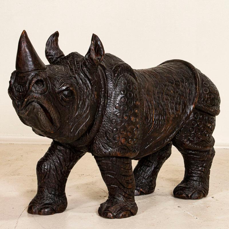 Diese imposante und beeindruckende Holzskulptur eines Nashorns verleiht jedem Raum eine starke Präsenz. Sehen Sie sich die Fotos an:: um die handgeschnitzten Details wie Mund:: Füße und Horn zu erkennen. Es gibt zwar einen altersbedingten Riss