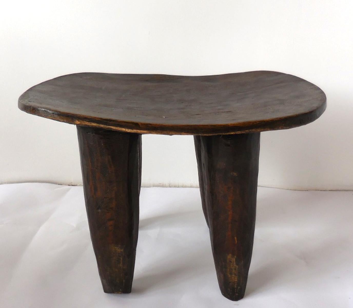 Carved out of one piece of wood, this is a traditional tribal stool from the Senufo tribe in Mali. Conical legs and slightly undulating top. Soft worn patina. Can be used as a stool or a side table.