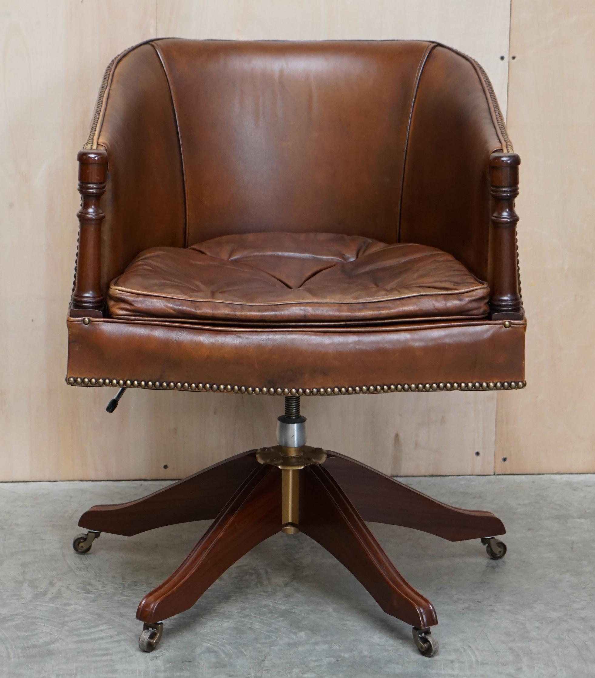 Nous sommes ravis d'offrir à la vente ce charmant fauteuil de capitaine pivotant en cuir marron teint à la main, avec des boutons flottants de style Thomas Chippendale sur le coussin.

Cette pièce est très décorative, les pieds et les accoudoirs