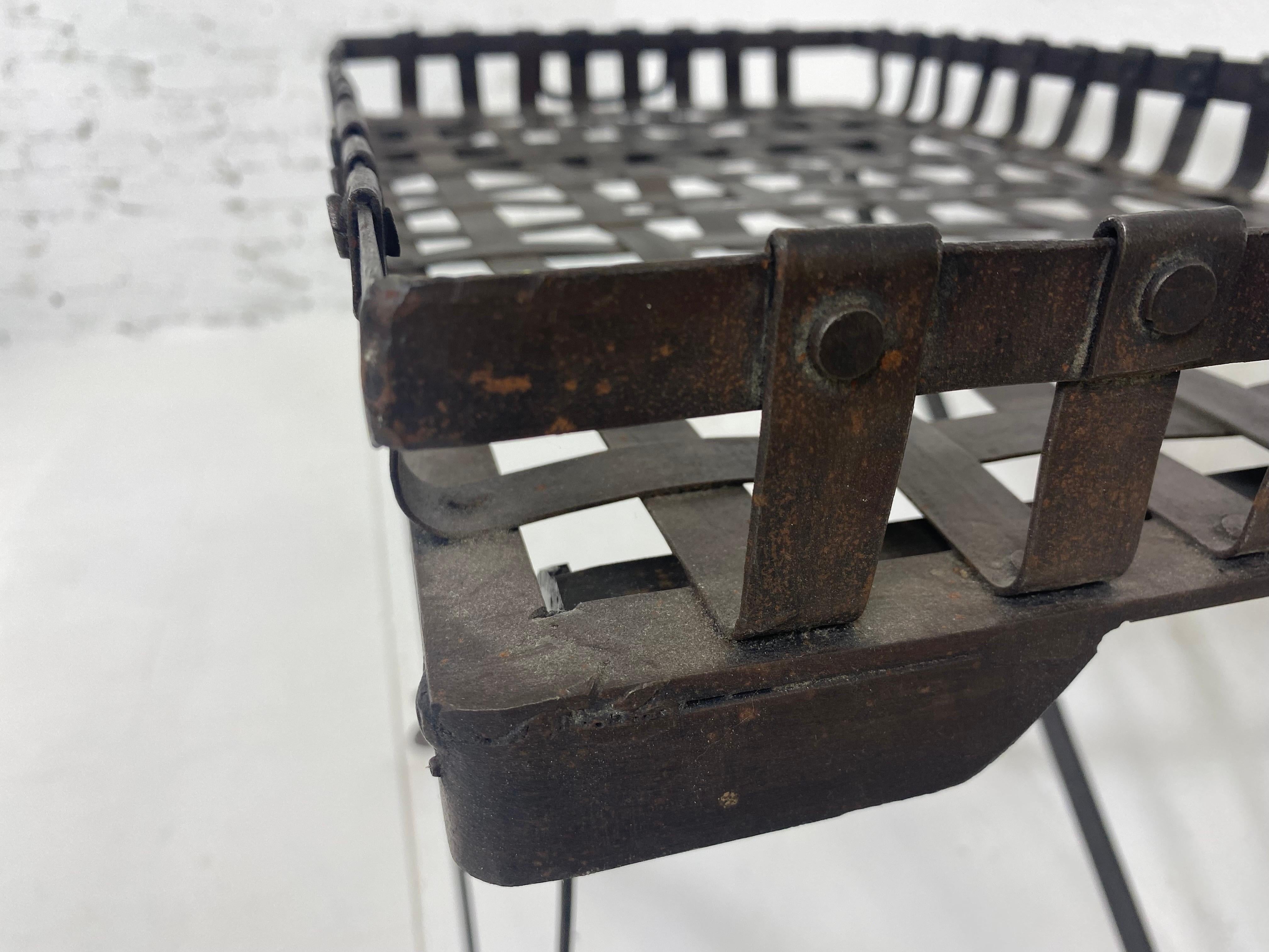 This is a vintage hand forge wrought iron campaign style tray with stand. This vintage French tray has an adjustable stand that can go higher or lower to coffee table height or tray height. The tray has a basket weave pattern in wrought iron with