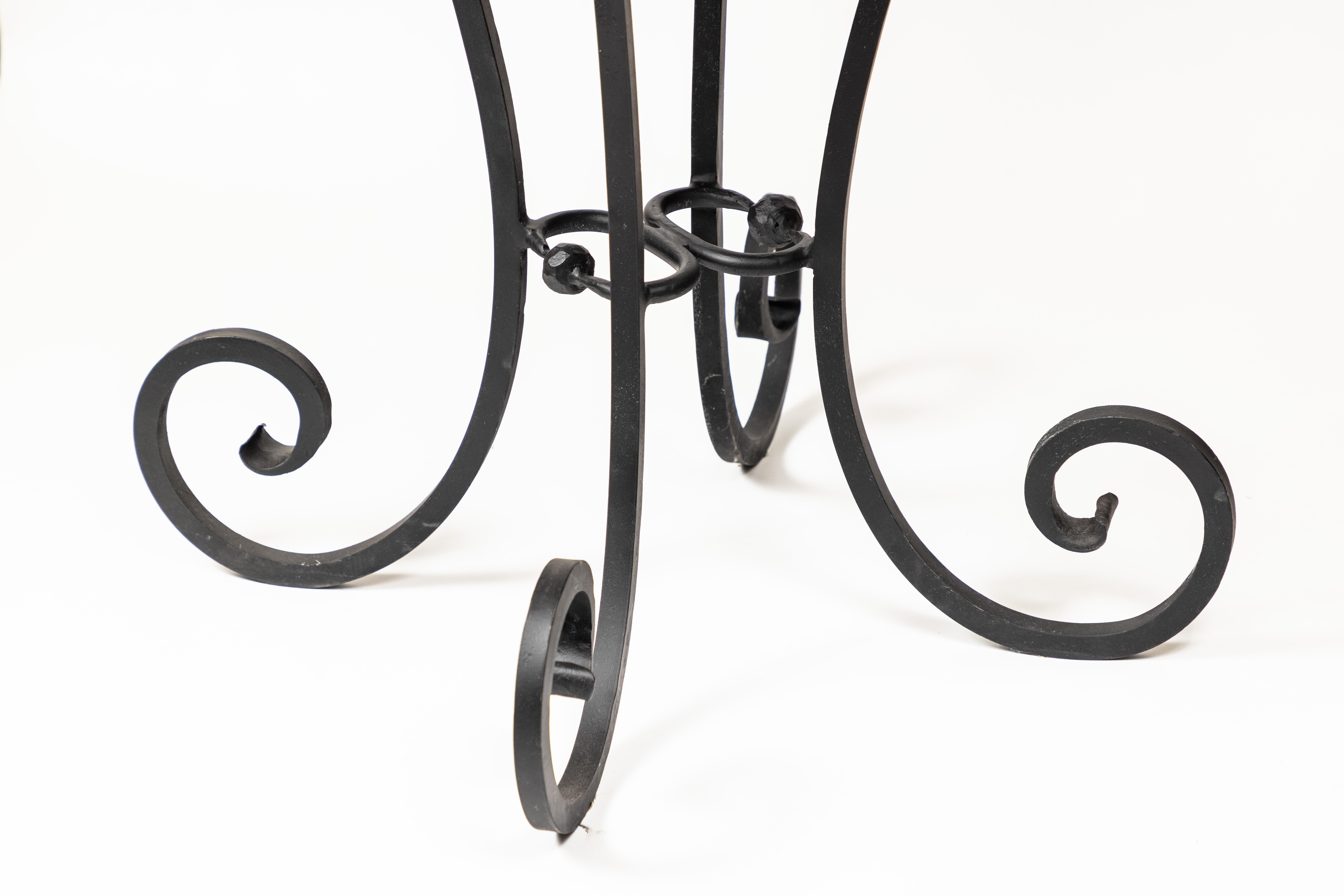 Vintage iron base table with scroll legs in black finish and new round soapstone top.

 