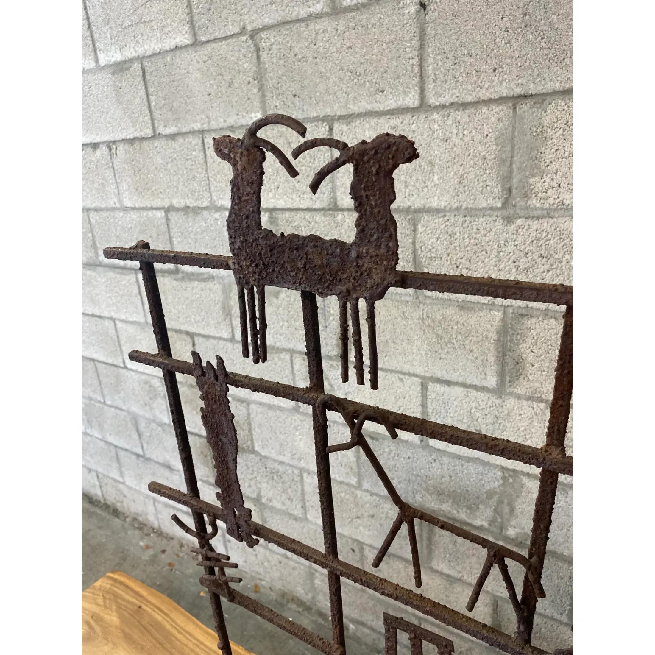 Fantastic vintage hand forged fire screen. A brilliant collection of gnarly icons placed randomly on a heavy grid. A real artistic masterpiece. Great to add some drama to any fireplace