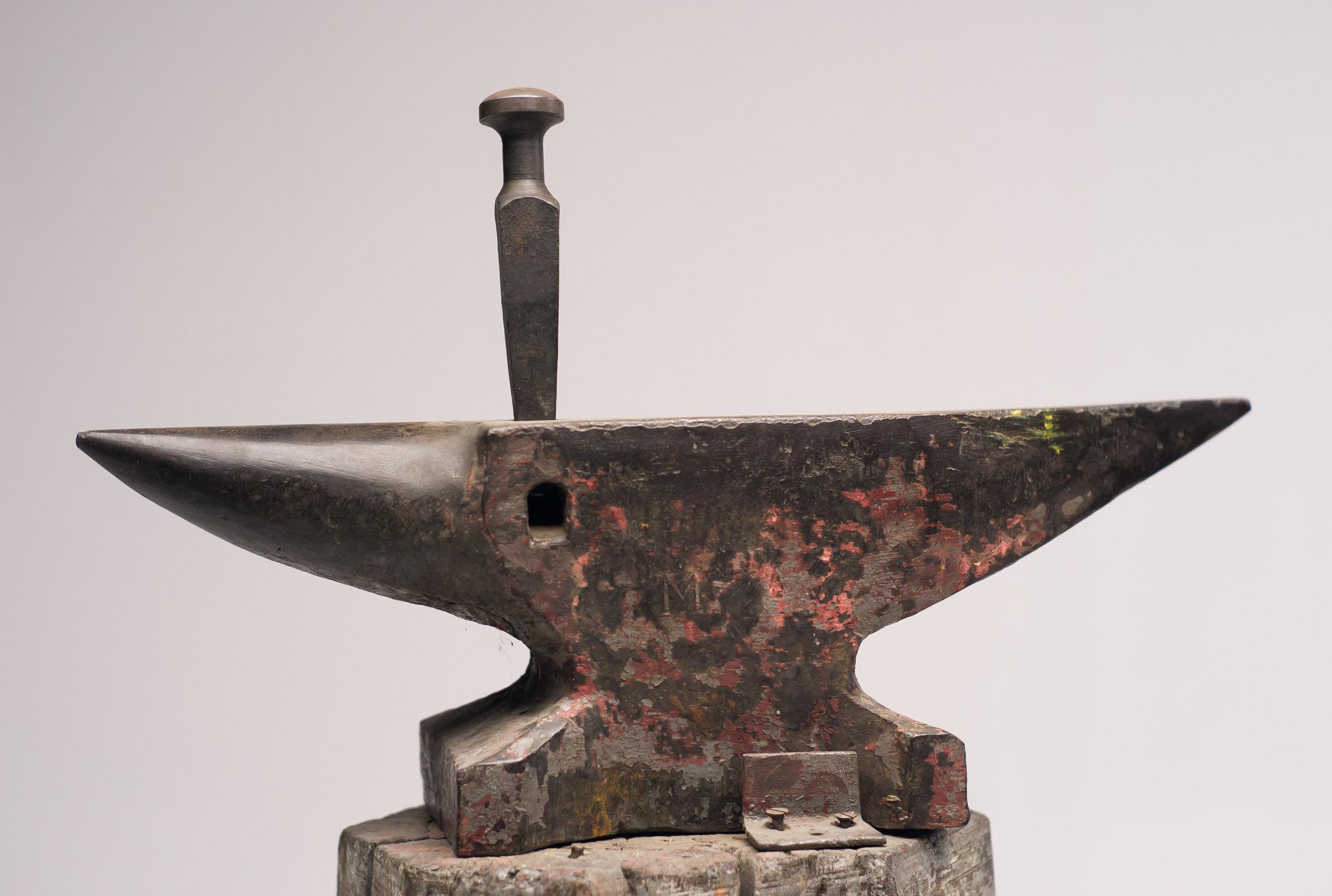 Vintage Dutch 19th century forged iron anvil on a wooden base with a beautiful patina.