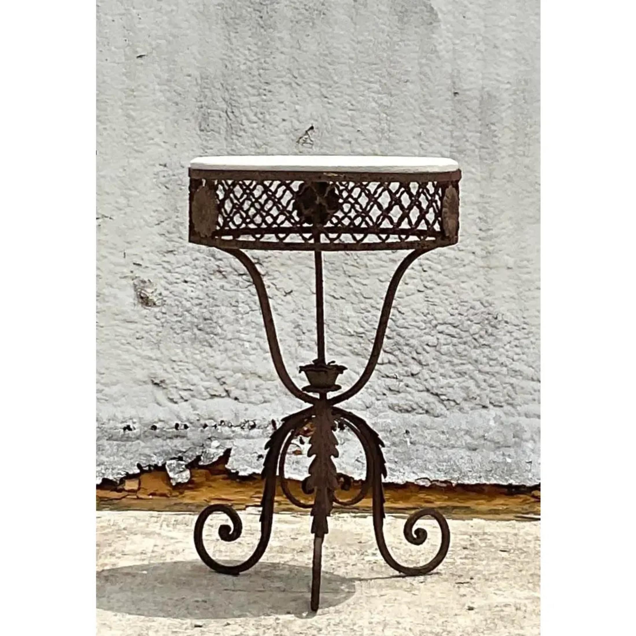 This side table is an elaborate vintage wrought iron table with a floral design and a marble top. Gorgeous all over patina from time. Perfect for a romantic garden moment. Acquired at a Palm Beach estate