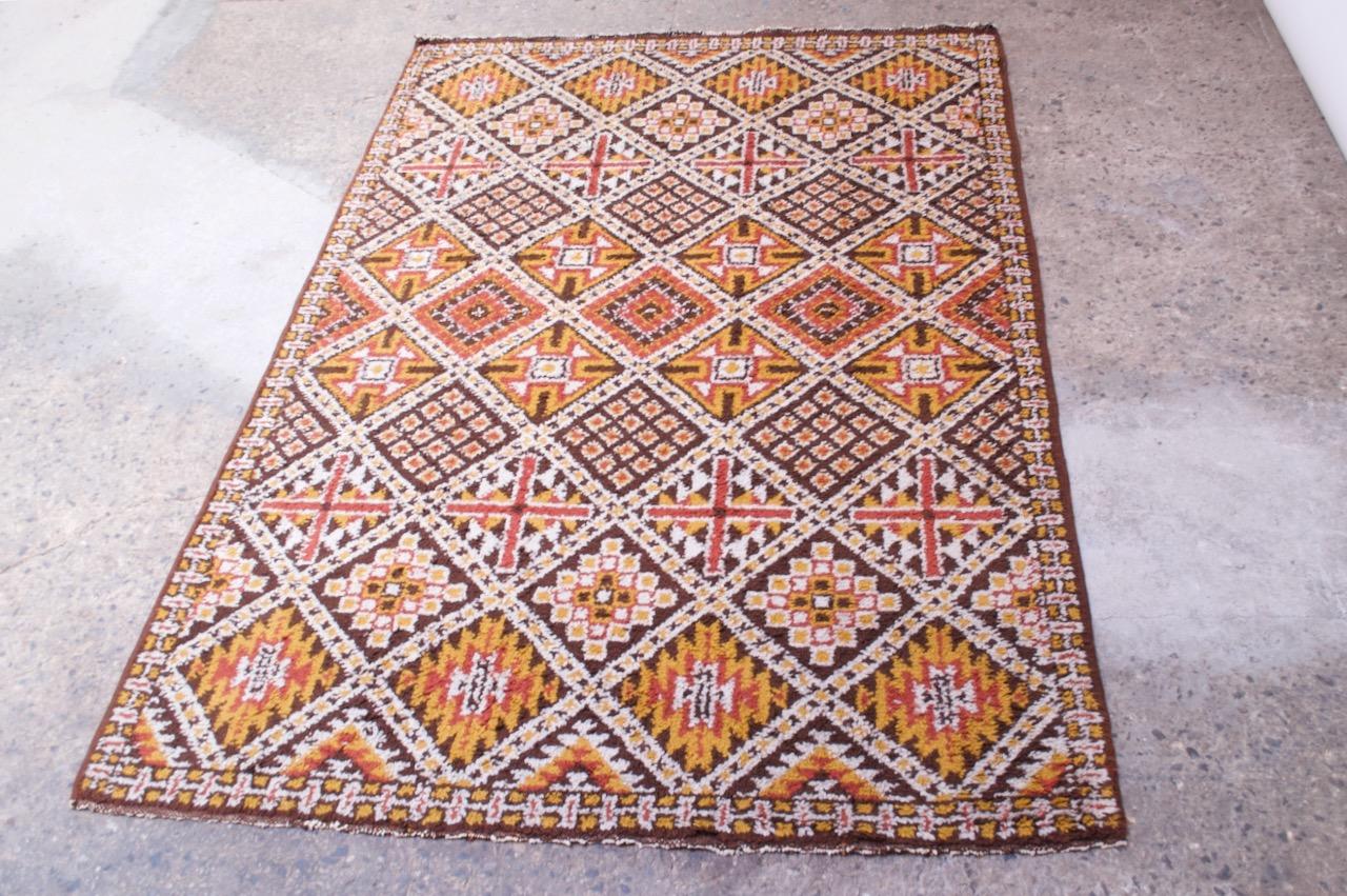 Tapis berbère tissé 100% laine, fabriqué à Rabat, Maroc à la S.A.F.T (Société Africaine de Filature et Tissage Rabat Maroc), vers les années 1970. Motif tribal en forme de diamant avec une utilisation attrayante des couleurs.
Mesures approximatives