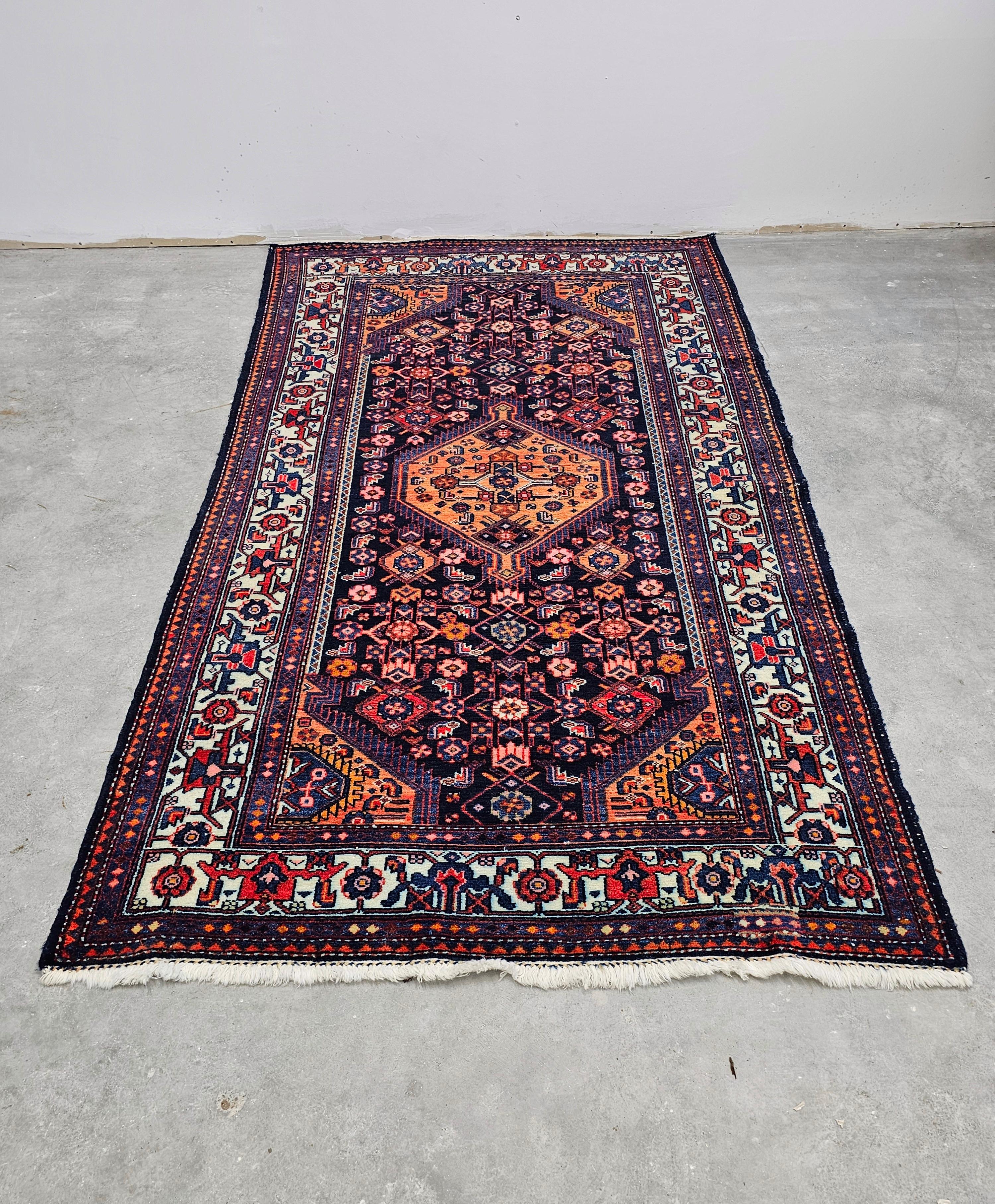 In questa inserzione troverai un tappeto Hamadan vintage annodato a mano. È realizzato in colori molto attraenti - arancione e viola - che creano un netto contrasto che si adatta a diversi tipi di interni. Prodotto in Iran negli anni