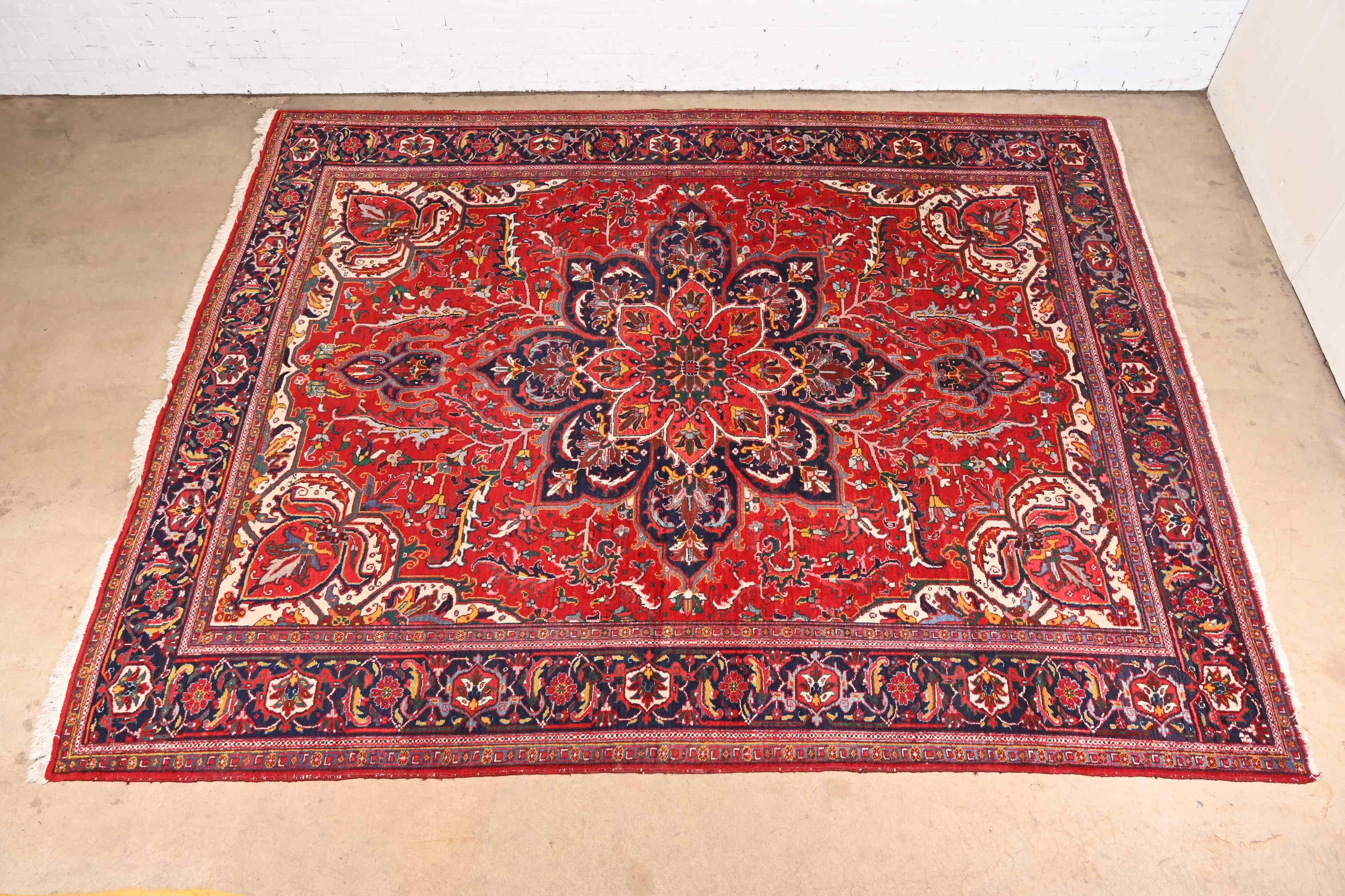 A gorgeous vintage hand-knotted Persian Heriz room size wool rug

Mid-20th Century

Beautiful floral design, with predominant colors in red, blue, gold, green, and ivory.

Measures: 10' x 12'4