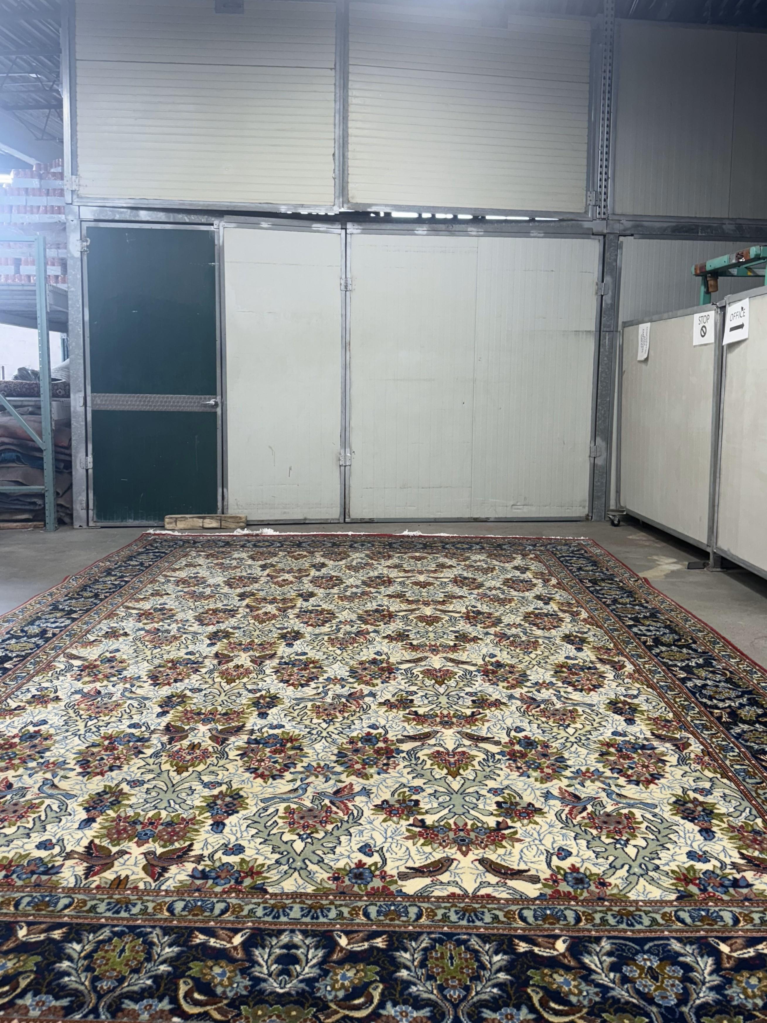 A Vintage Hand-Knotted Persian Isfahan Room-Sized Rug - 10'10 x 15'6 with a floral design with birds and flowers, showcasing intricate patterns and details.

