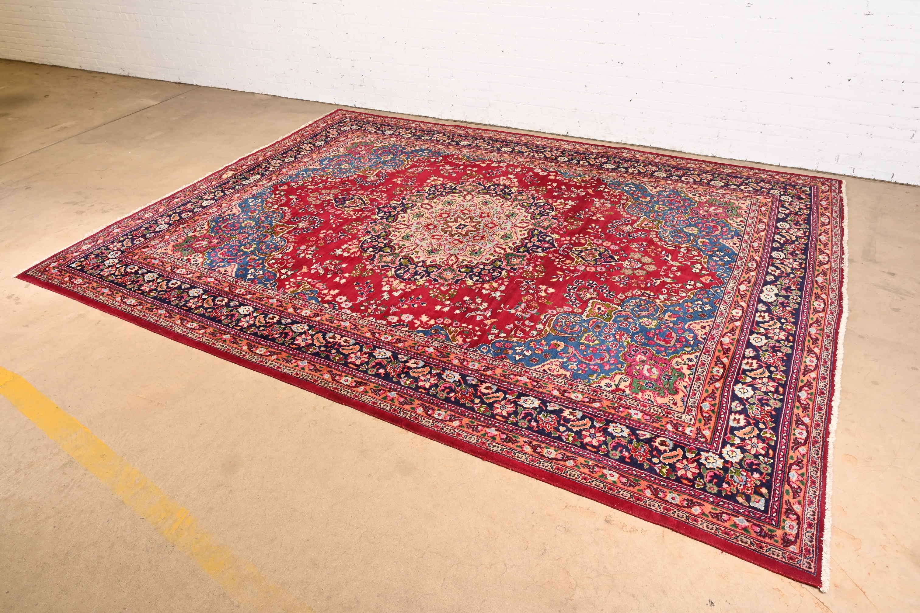 A gorgeous vintage hand-knotted Persian Kashan large room size wool rug

Circa Mid-20th Century

Beautiful floral design, with predominant colors in red, pink, blue, green, and ivory.

Measures: 9'11