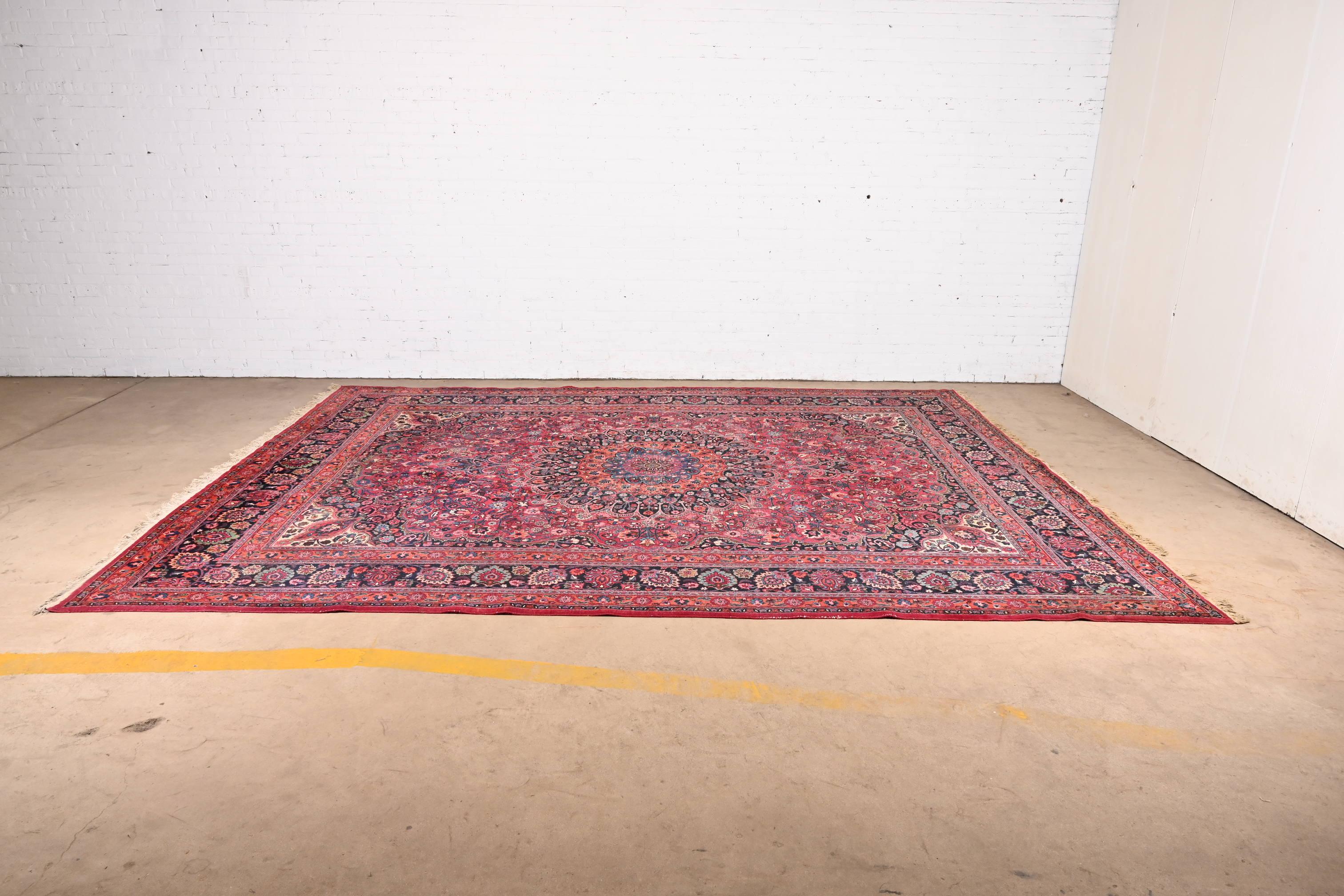 Magnifique tapis ancien en laine nouée à la main de style persan Moud.

Circa Mid-20th Century

Elle présente de magnifiques gerbes et bouquets de fleurs traditionnels, dont les couleurs prédominantes sont le rouge, le bleu, le vert et