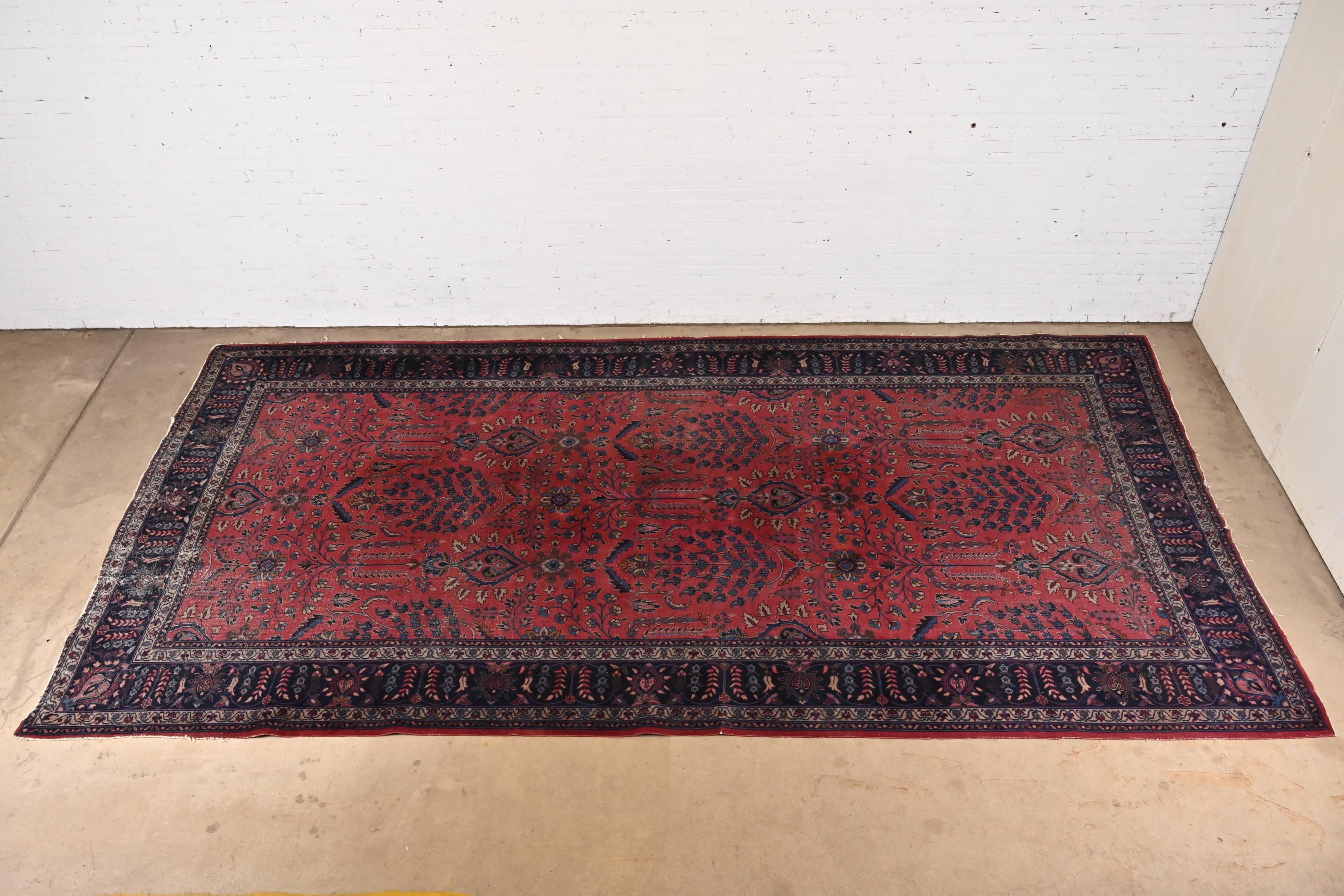 A gorgeous vintage hand-knotted Persian Sarouk room size rug

Circa 1940s

Classic floral design, with predominant colors in red, blue, and ivory.

Measures: 8'11